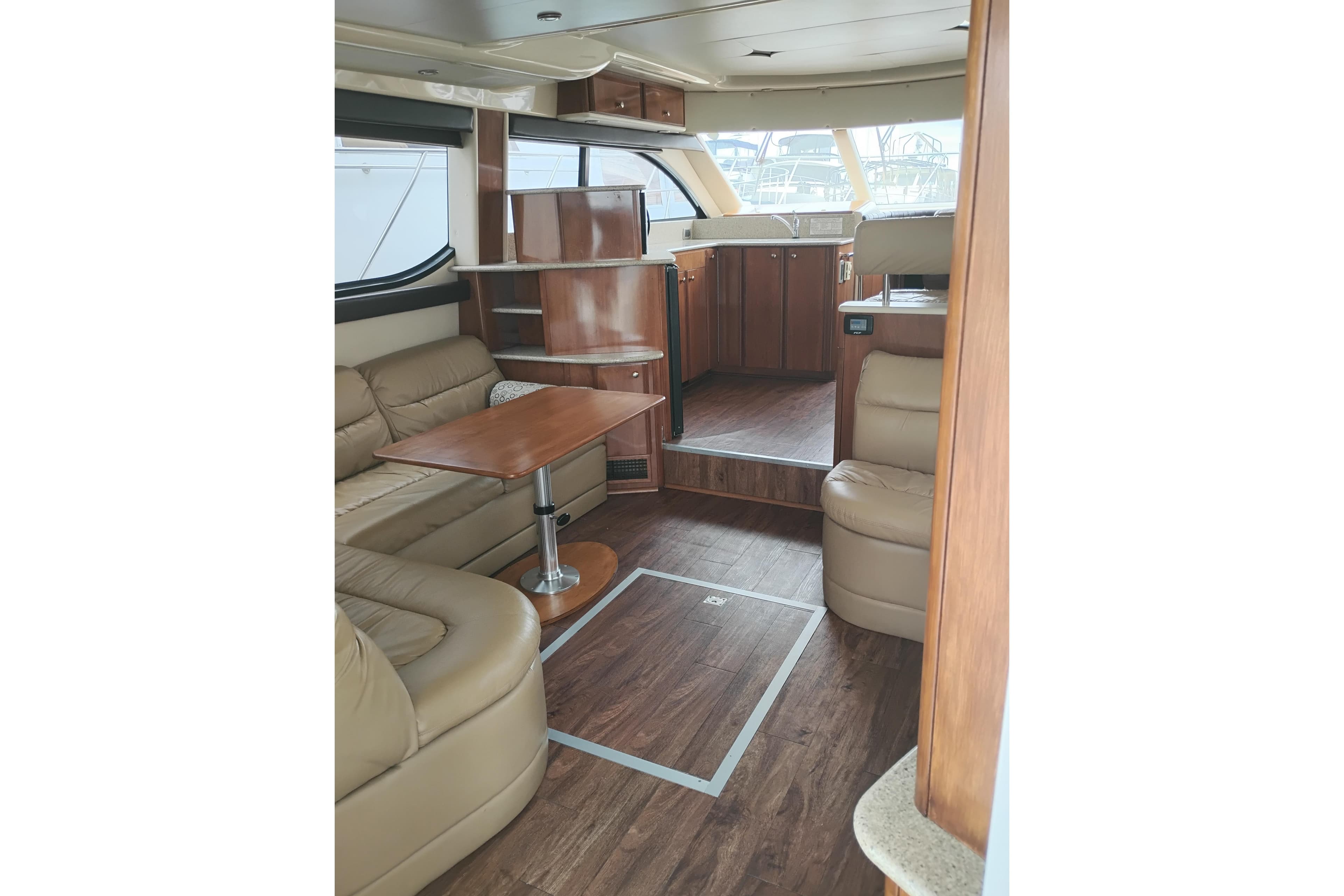 Luxurious interior of a 2006 Meridian 411 Sedan yacht with leather seating and wooden accents.