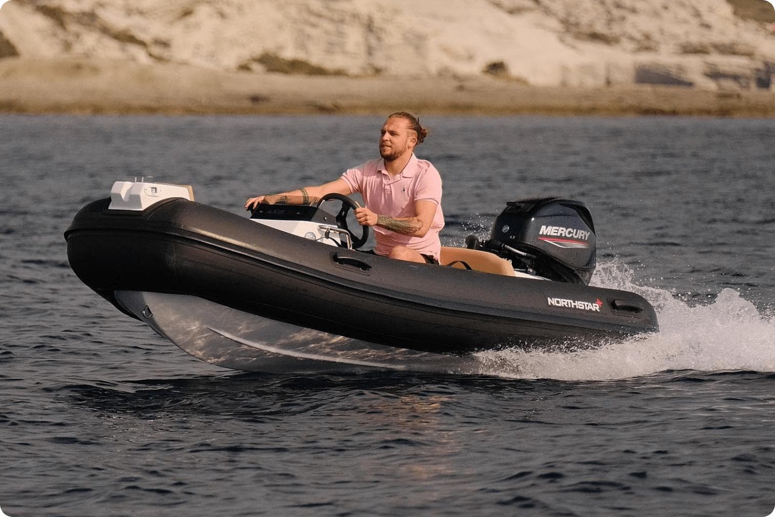 Man driving 2022 Northstar Axis 3.4 boat with Mercury engine on open water.