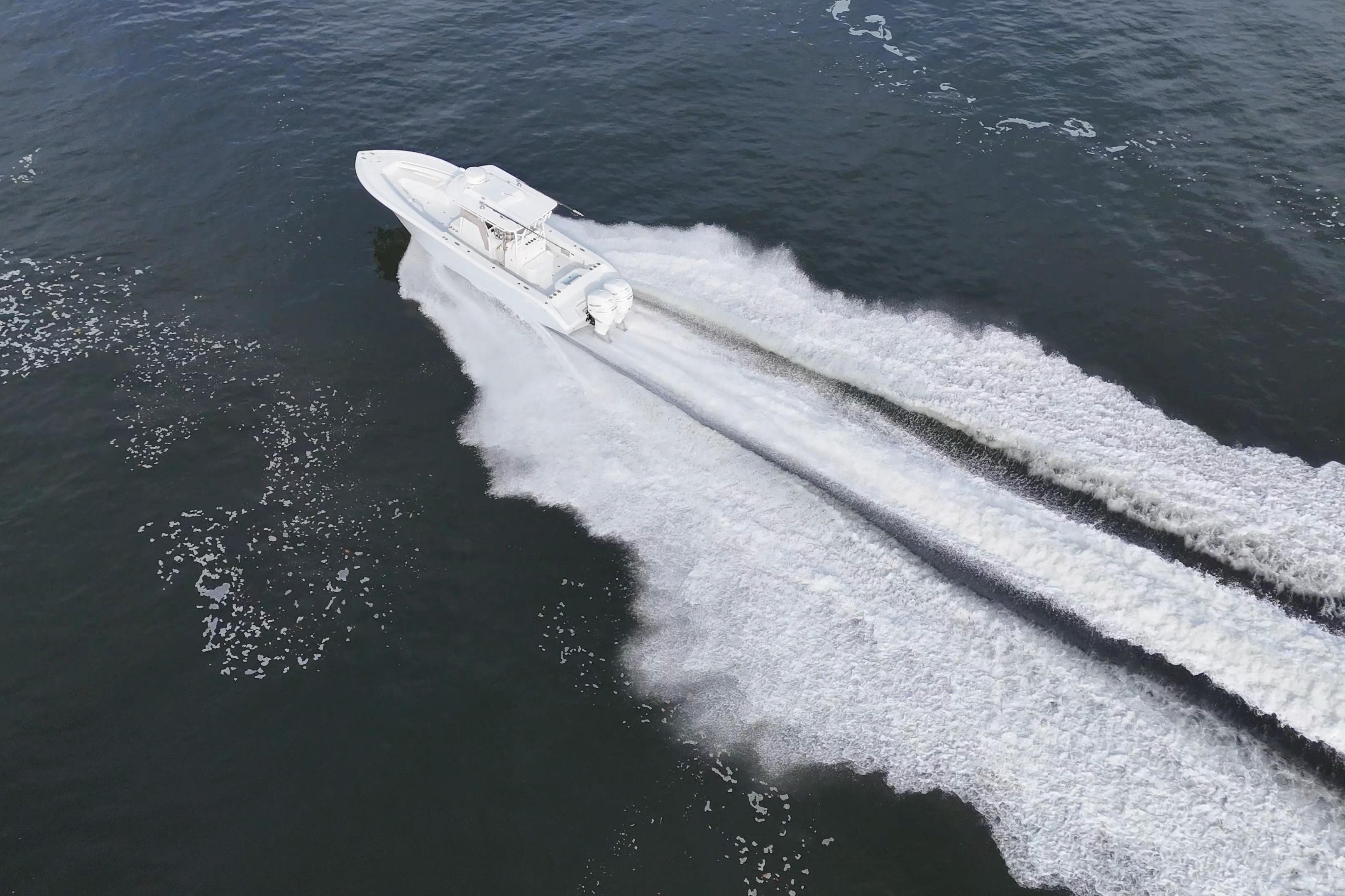 Aerial view of 2023 Yellowfin 32 Offshore boat speeding on water.