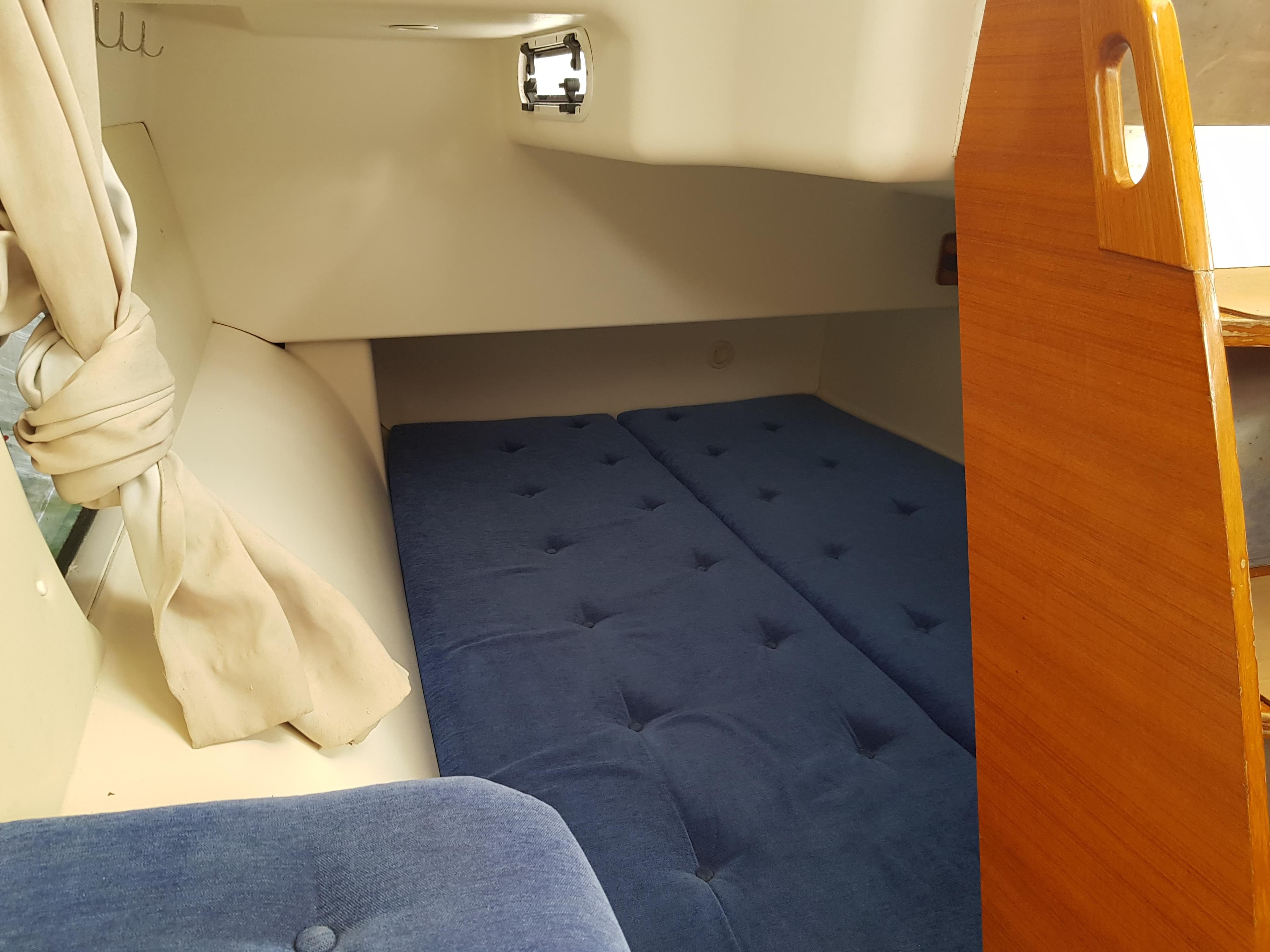 Interior cabin of 2009 Dragonfly 35 Touring with blue cushions and wooden accents.