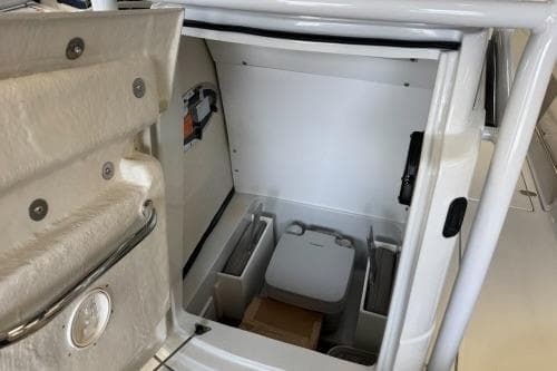2025 Crownline 230 FinSeeker boat interior storage compartment with portable toilet.