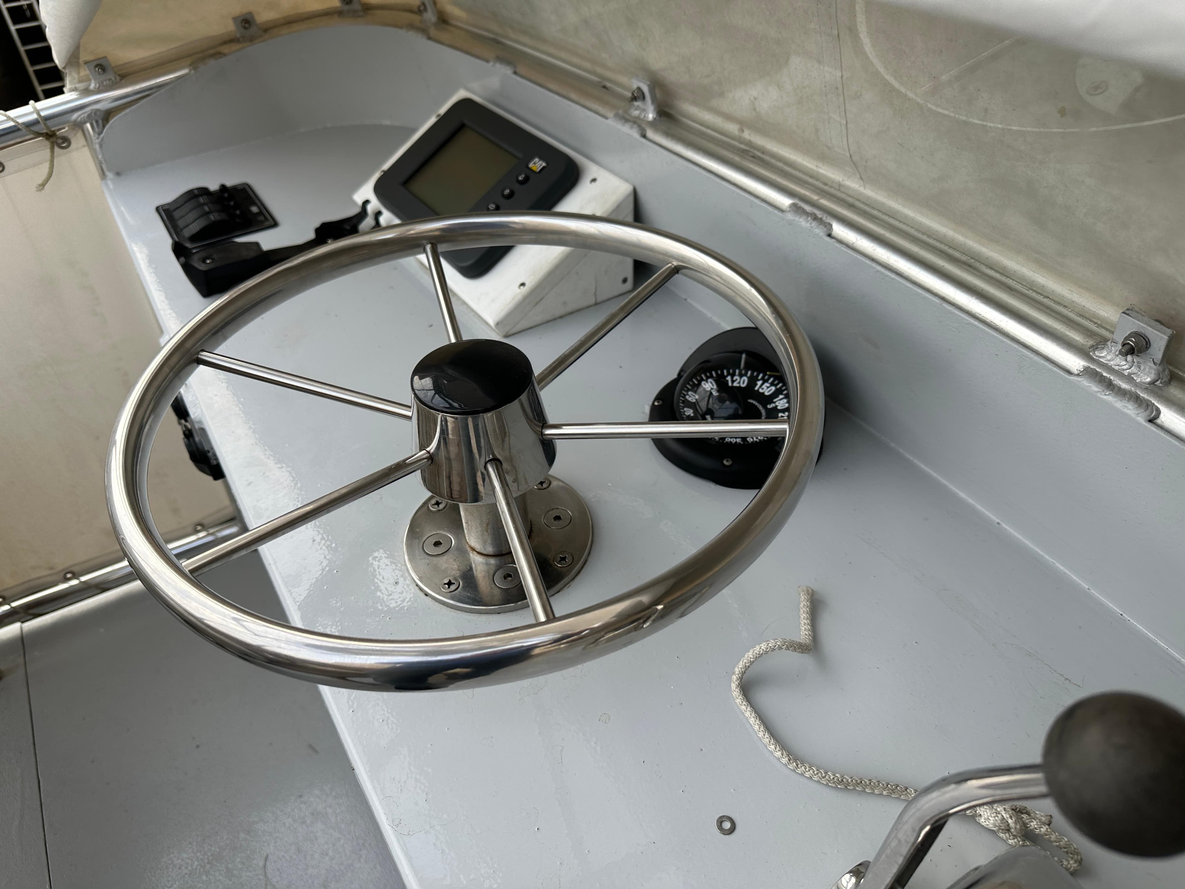 Steering wheel and compass on 2003 BHM Sport Fish boat dashboard.