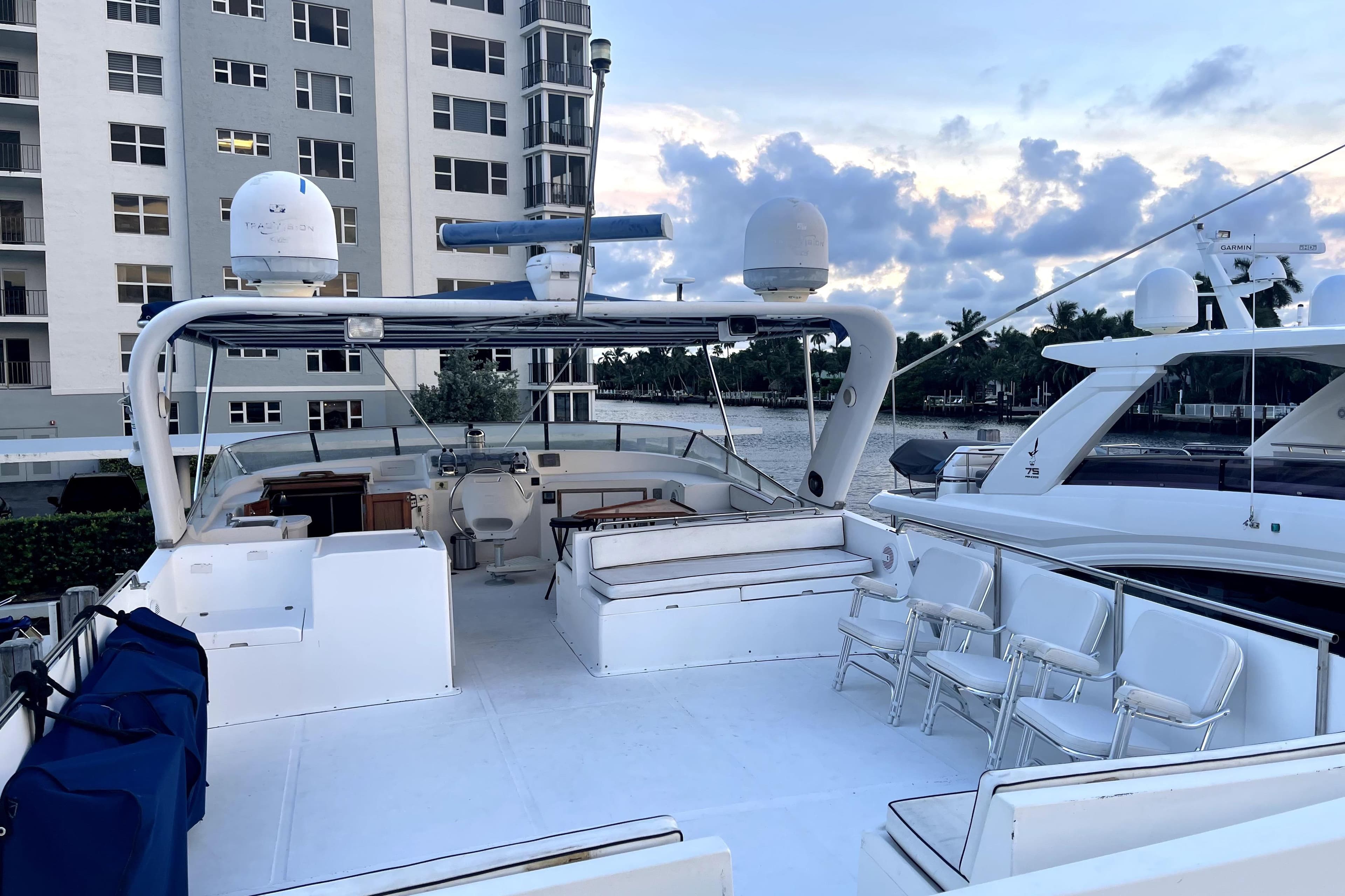 1988 Jefferson Marquessa 60 MY yacht deck with seating, docked near waterfront buildings.