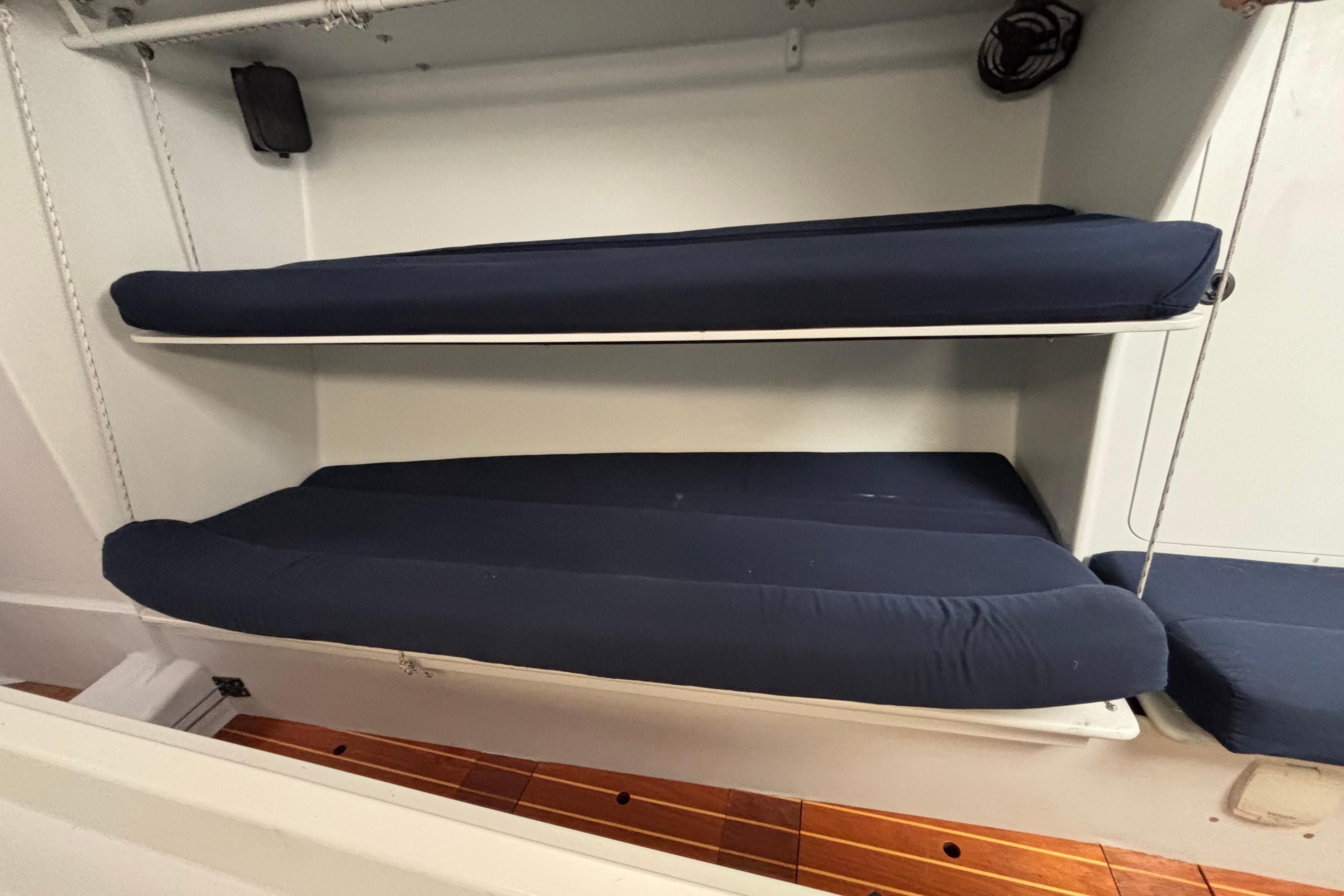 Bunk beds with navy cushions in a 1995 Tripp 47 sailboat interior.