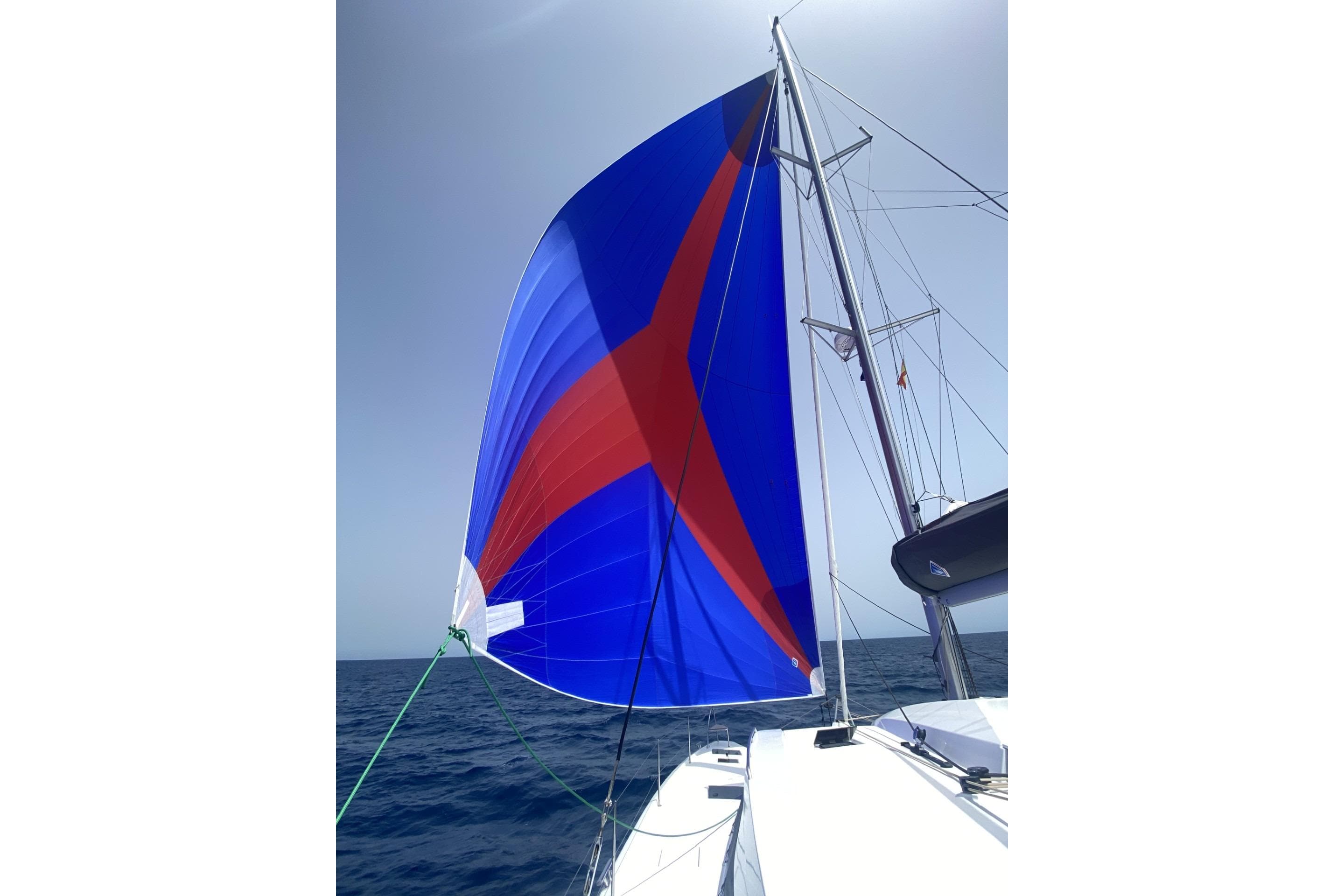 2022 Fountaine Pajot Elba 45 Catamaran with vibrant blue and red sail on open sea.