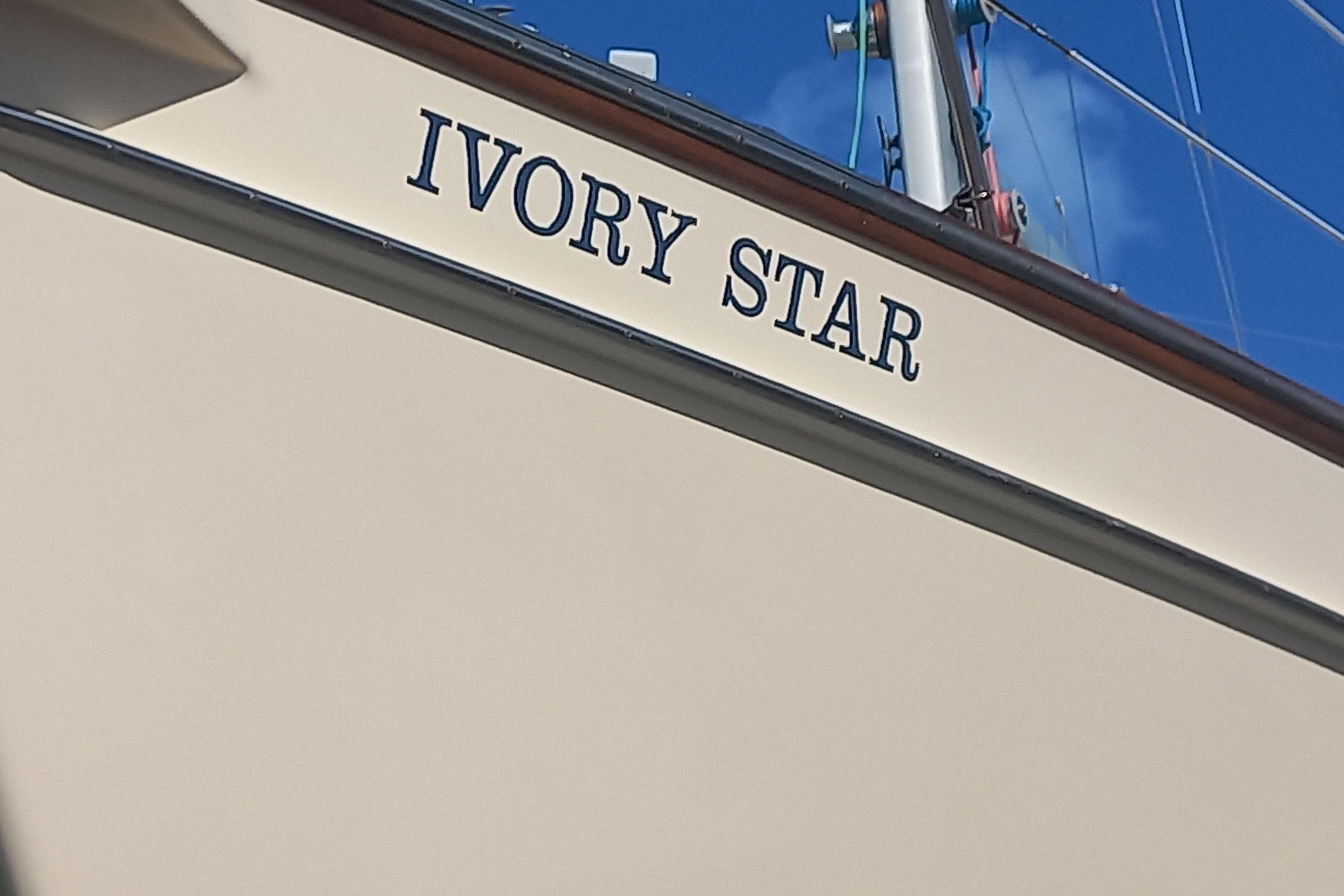 Sailboat "Ivory Star," Island Packet 350, 1999 model, with clear blue sky background.
