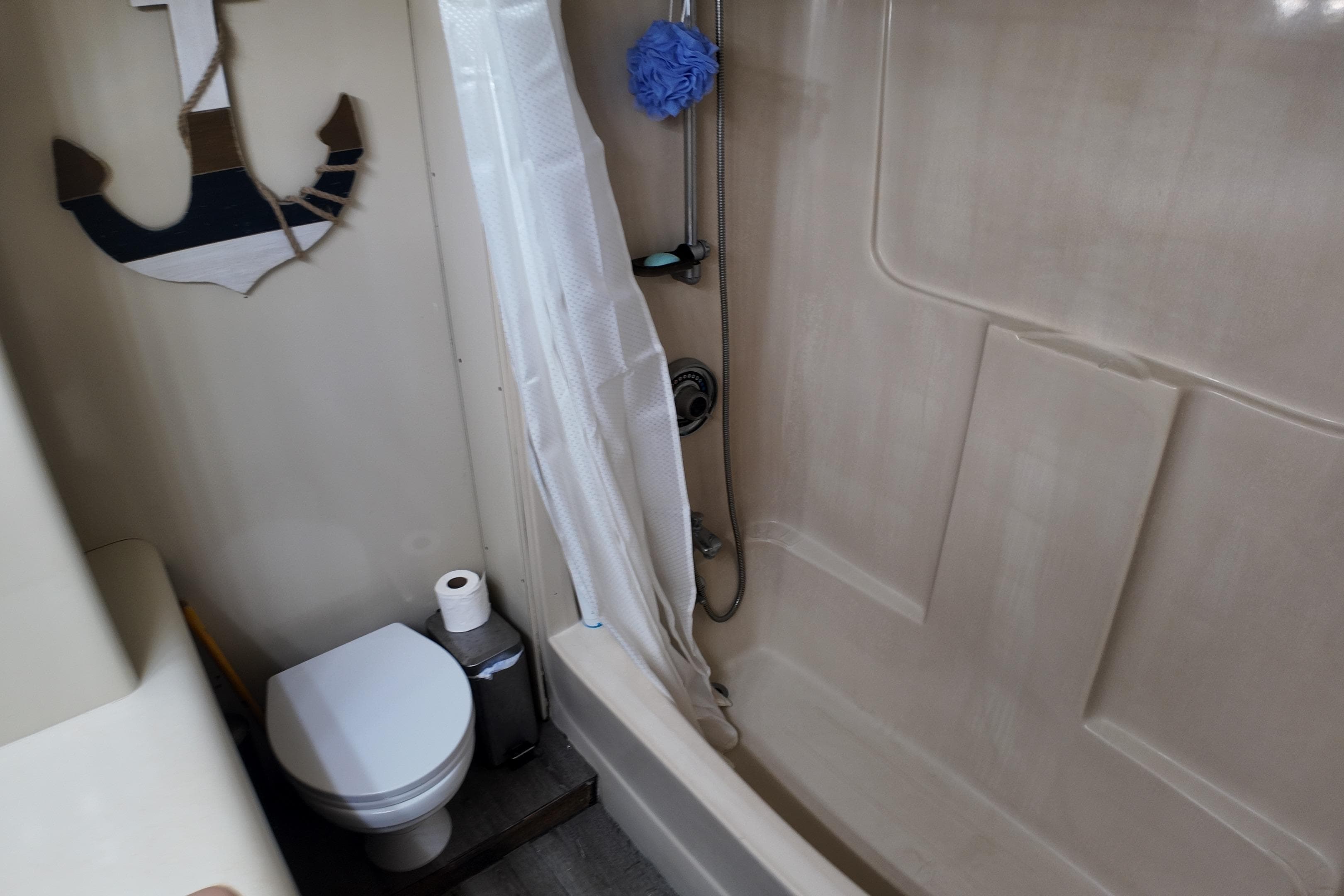 Bathroom in 1987 Viking Gulfstar boat with shower, toilet, and anchor decor.