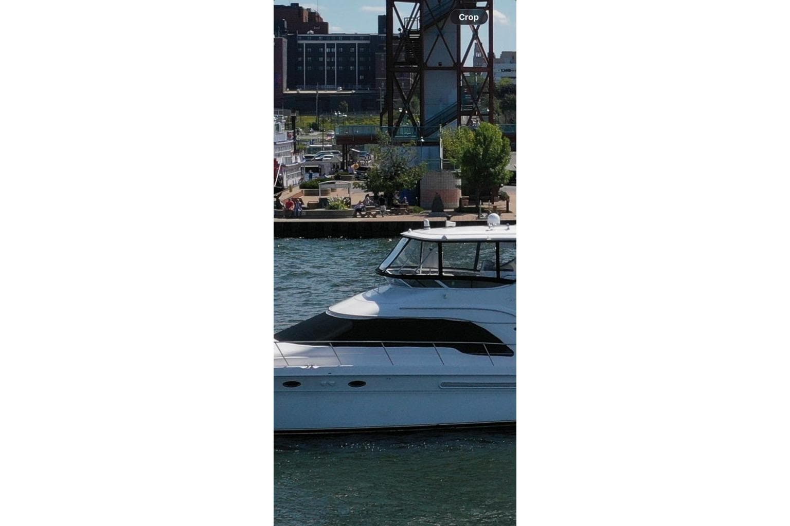 2002 Sea Ray 560 Sedan Bridge yacht cruising near urban waterfront.