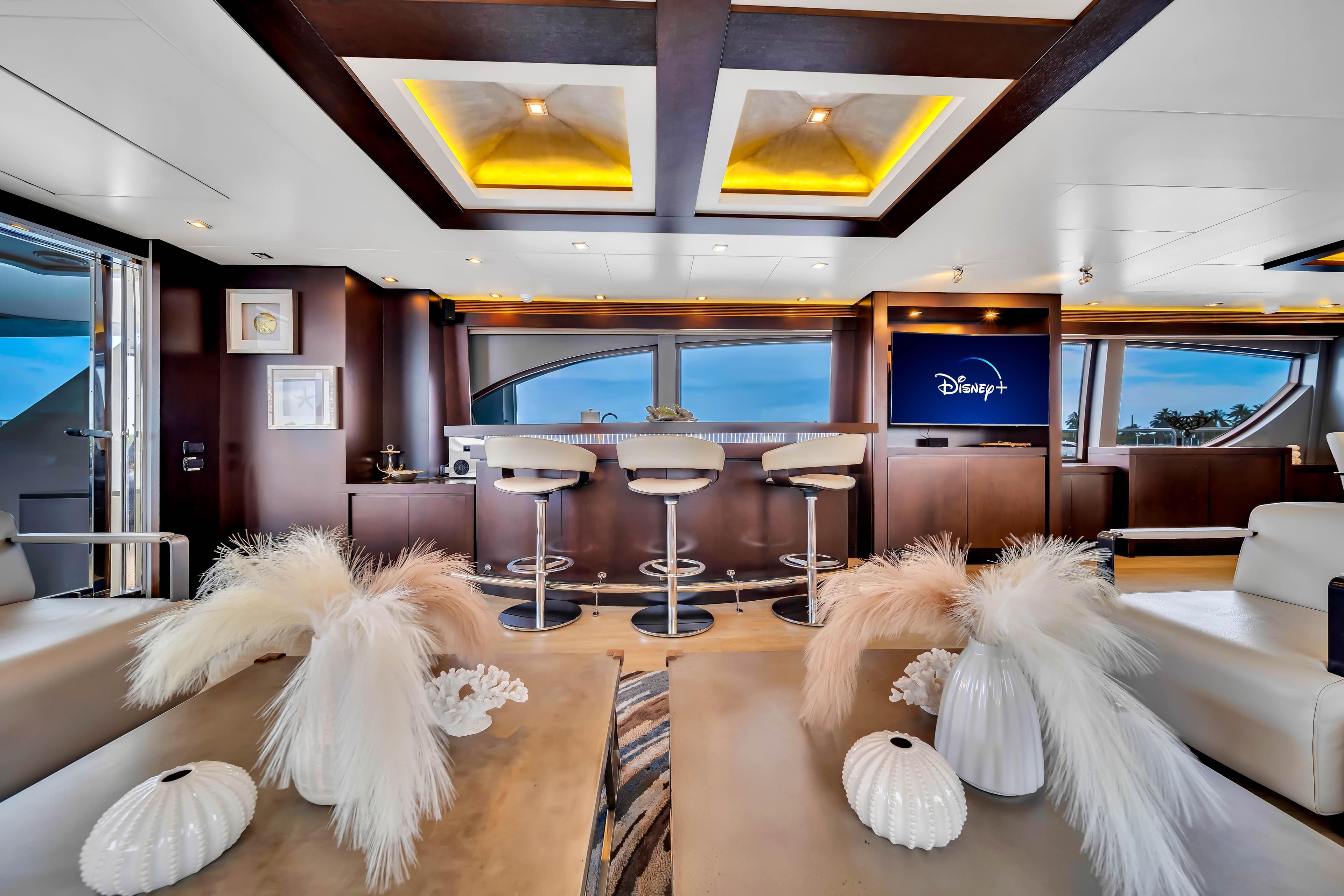 Luxurious 2012 Azimut yacht interior with modern bar, elegant decor, and Disney+ on TV.