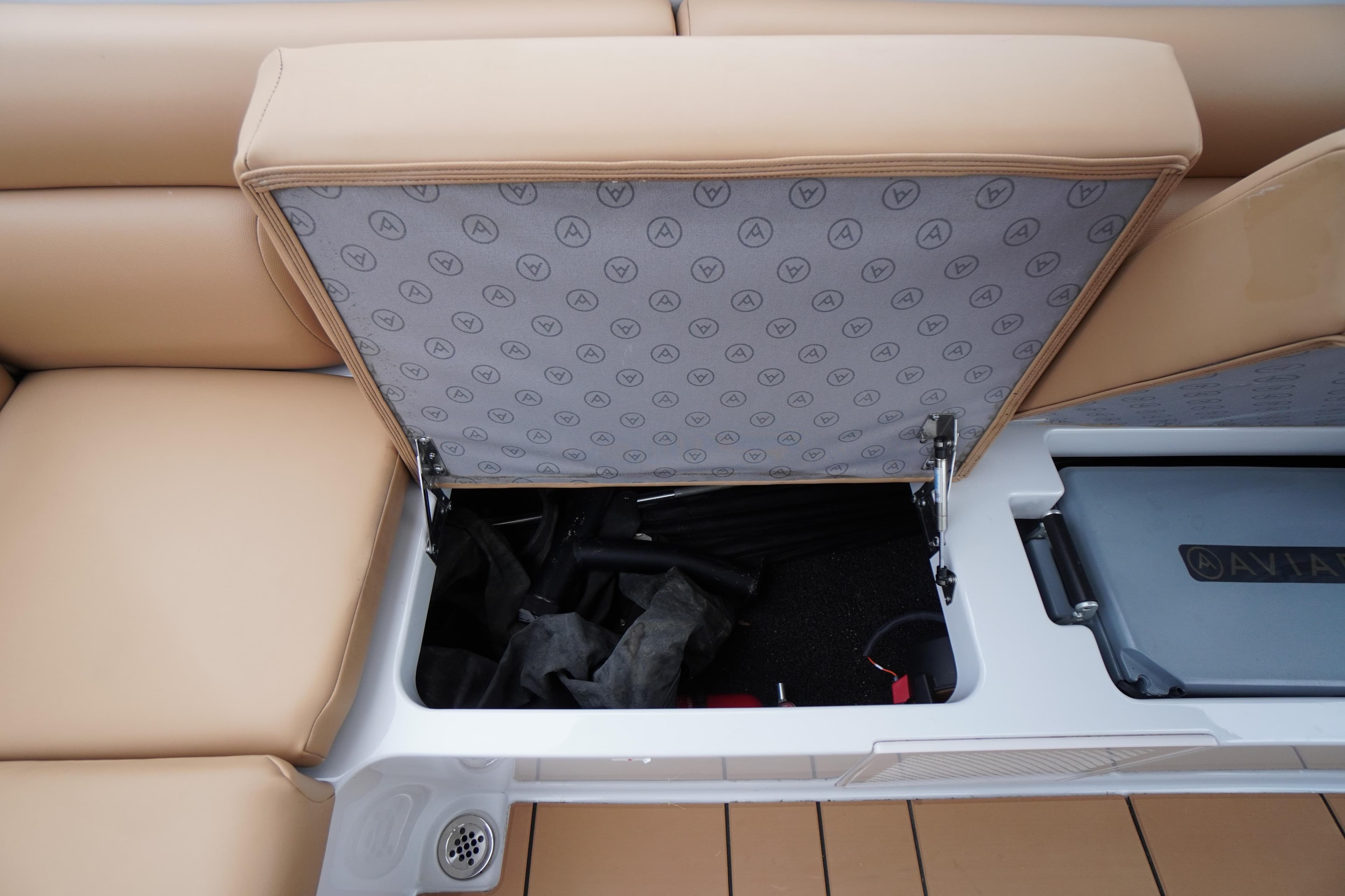 2020 Aviara AV32 OB boat storage compartment with tan seating and branded interior.