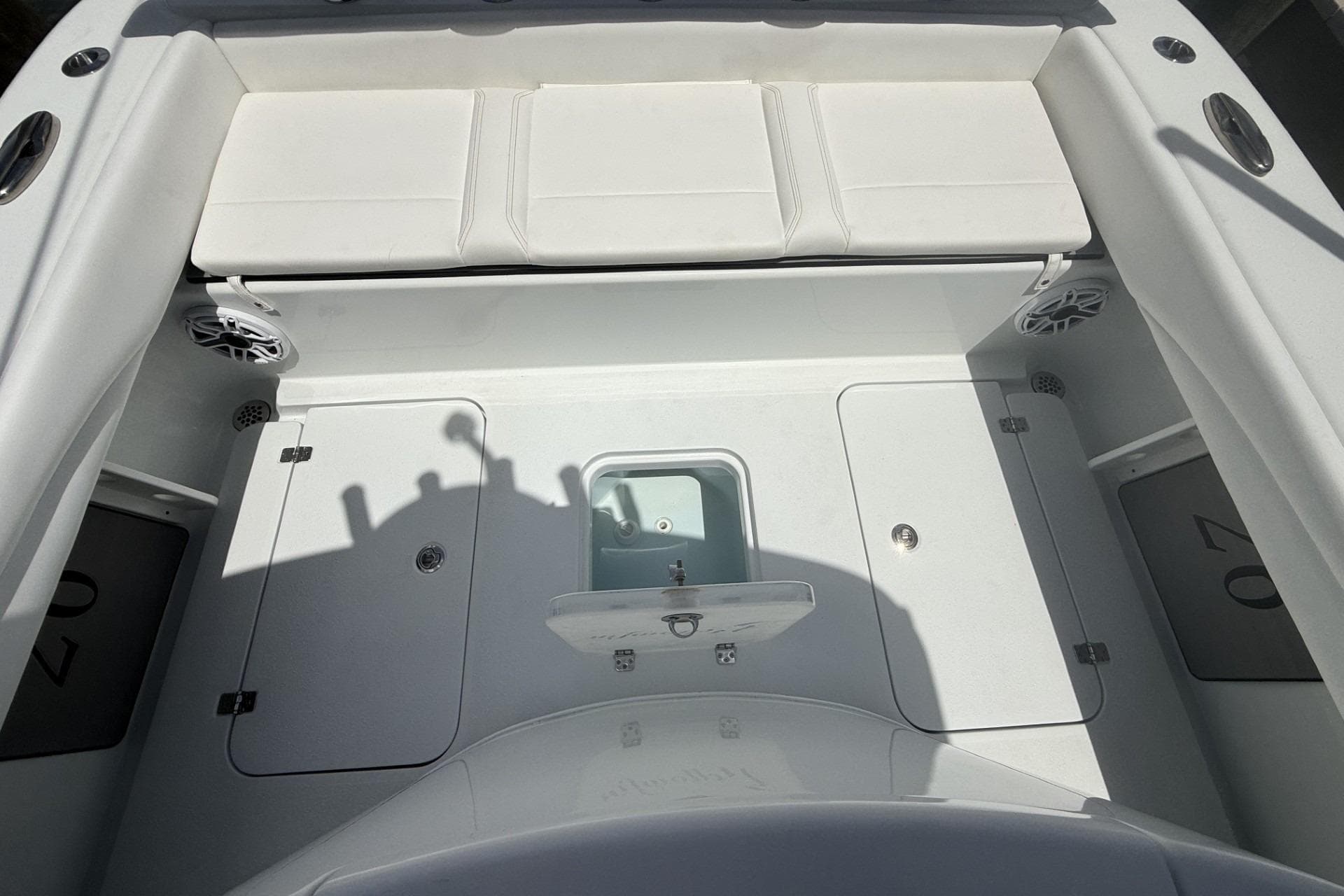 2023 Yellowfin 26 Hybrid boat interior with white seating and storage compartments.