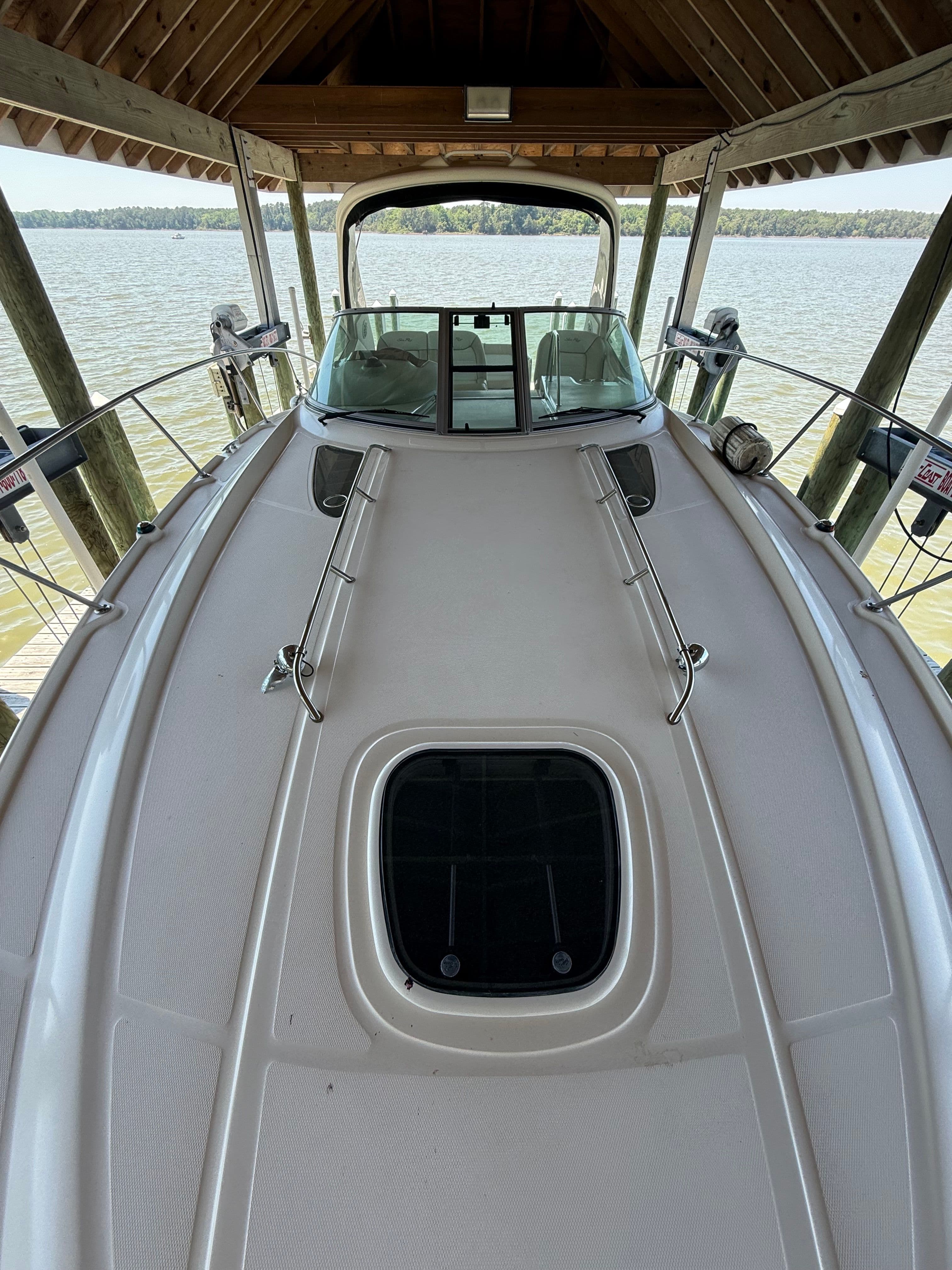 2012 Sea Ray Sundancer 350 on a lake under a wooden shelter.