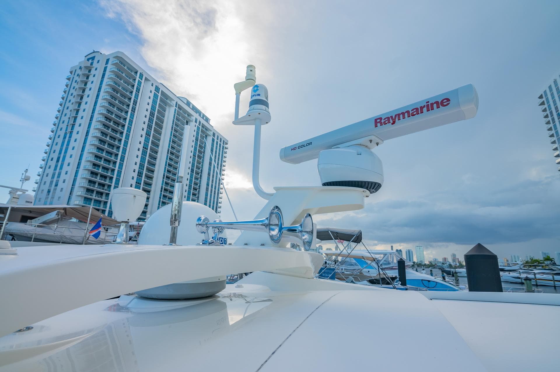2018 Sea Ray L590 yacht with Raymarine radar, docked near high-rise buildings.