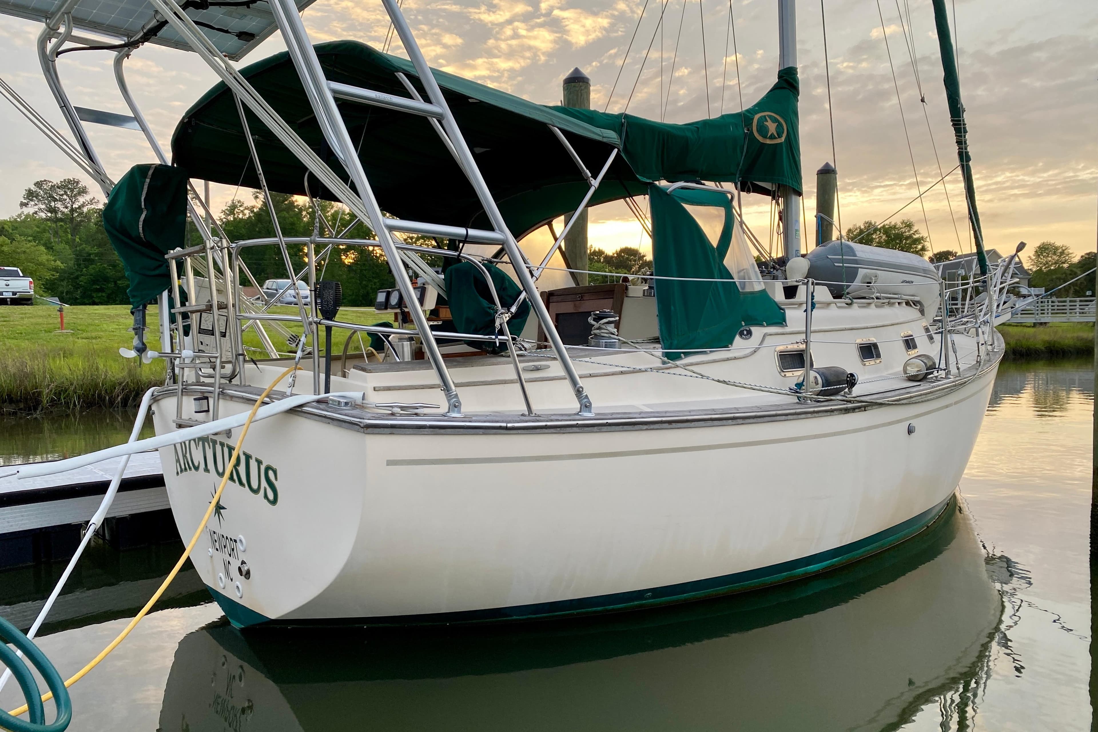 Sailboat Island Packet 29, 1992 model, docked at sunset with green canopy.