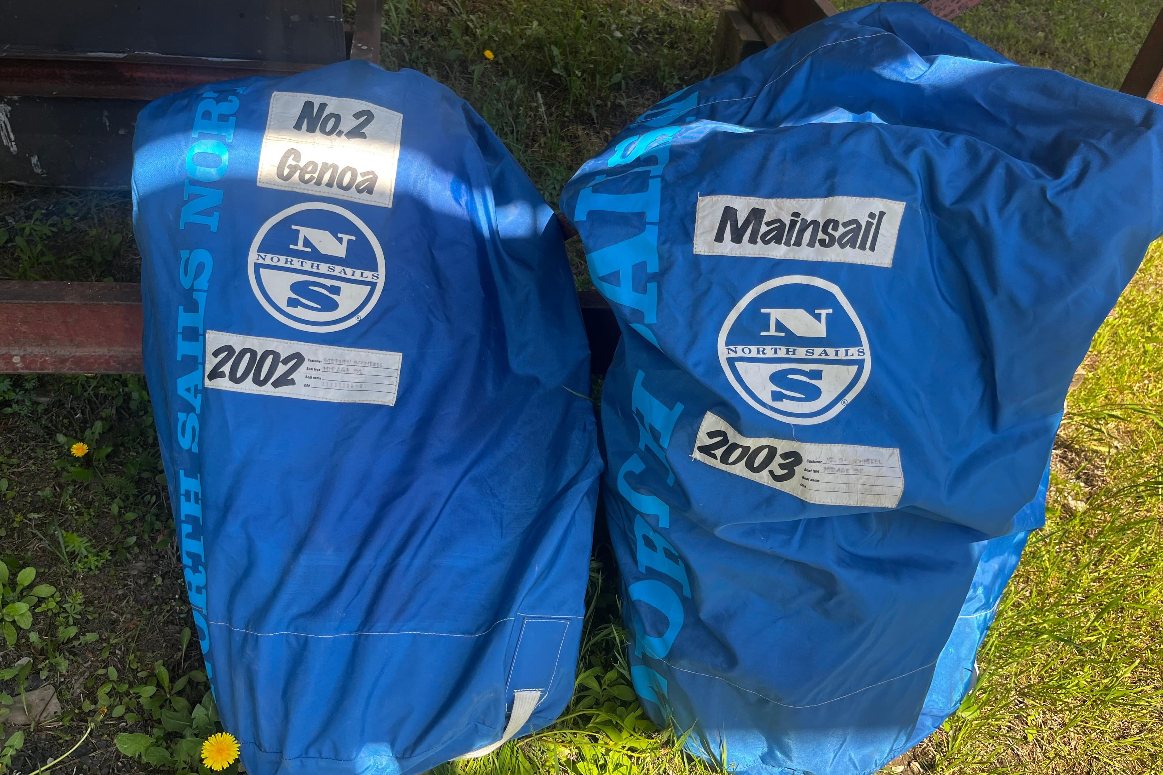Blue North Sails bags labeled "No.2 Genoa" and "Mainsail" for Mirage 32, 1988.