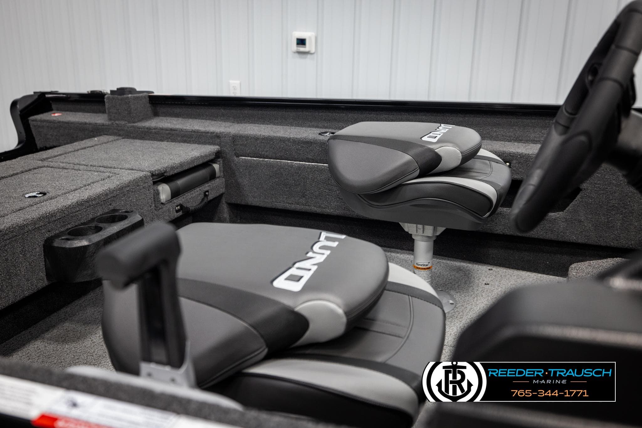 2025 Lund Adventure SS boat interior with gray seating and storage compartments.