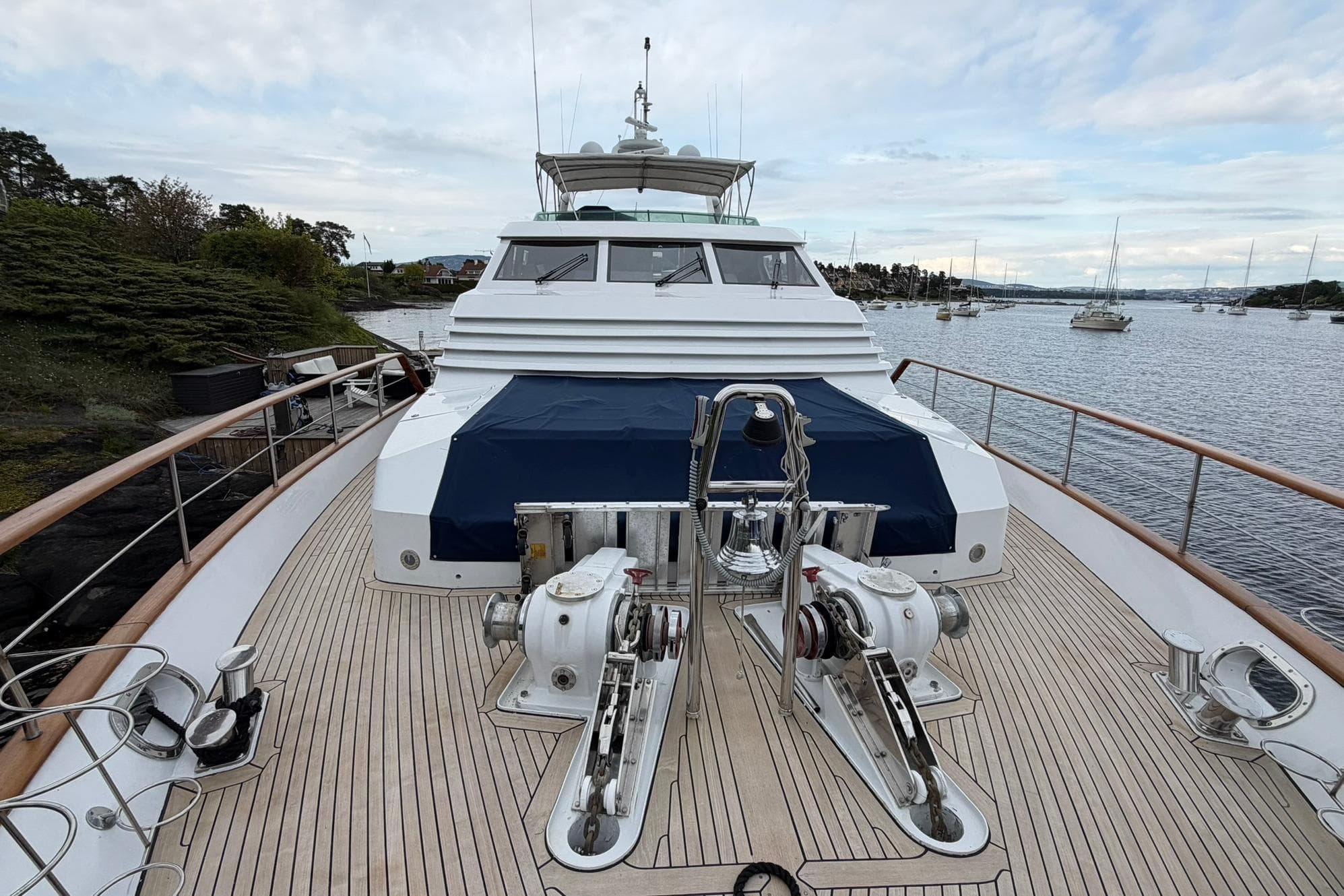 Luxury yacht Lowland Netship 97, 1990 model, docked with scenic waterway view.
