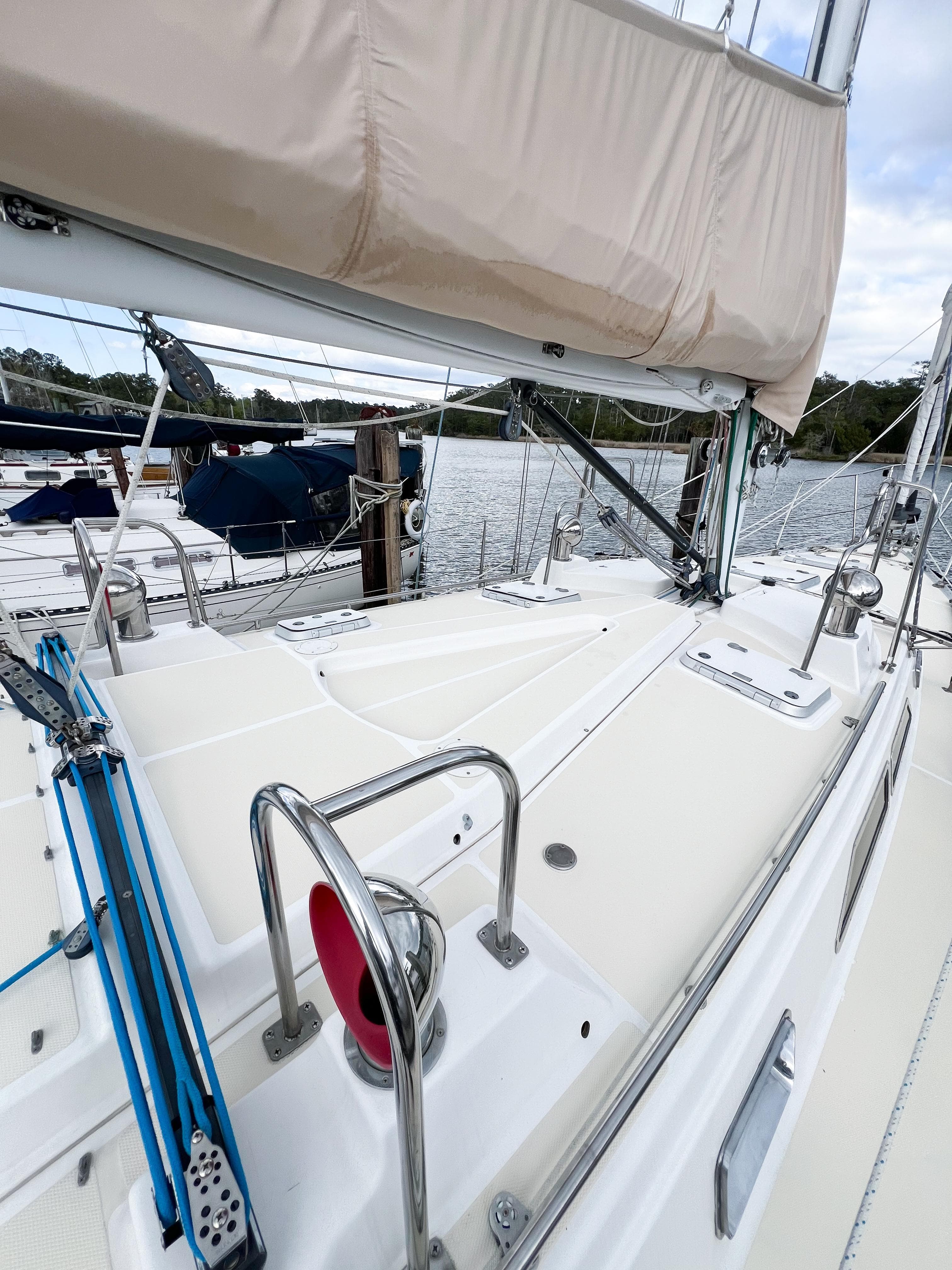 Sailboat deck view of 1998 Saga 43, featuring rigging and marina backdrop.