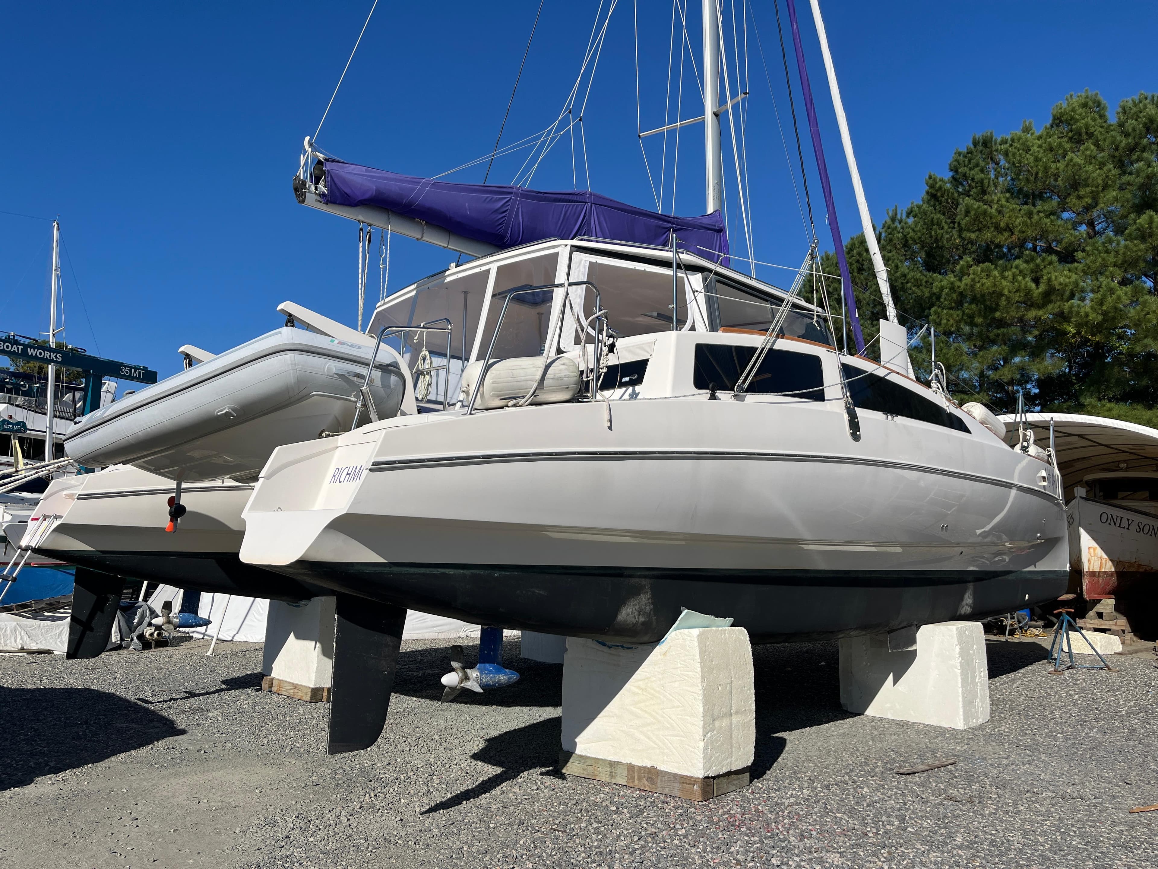 2018 Maine Cat 38 Electric catamaran on stands, with blue sail cover, in a boatyard.
