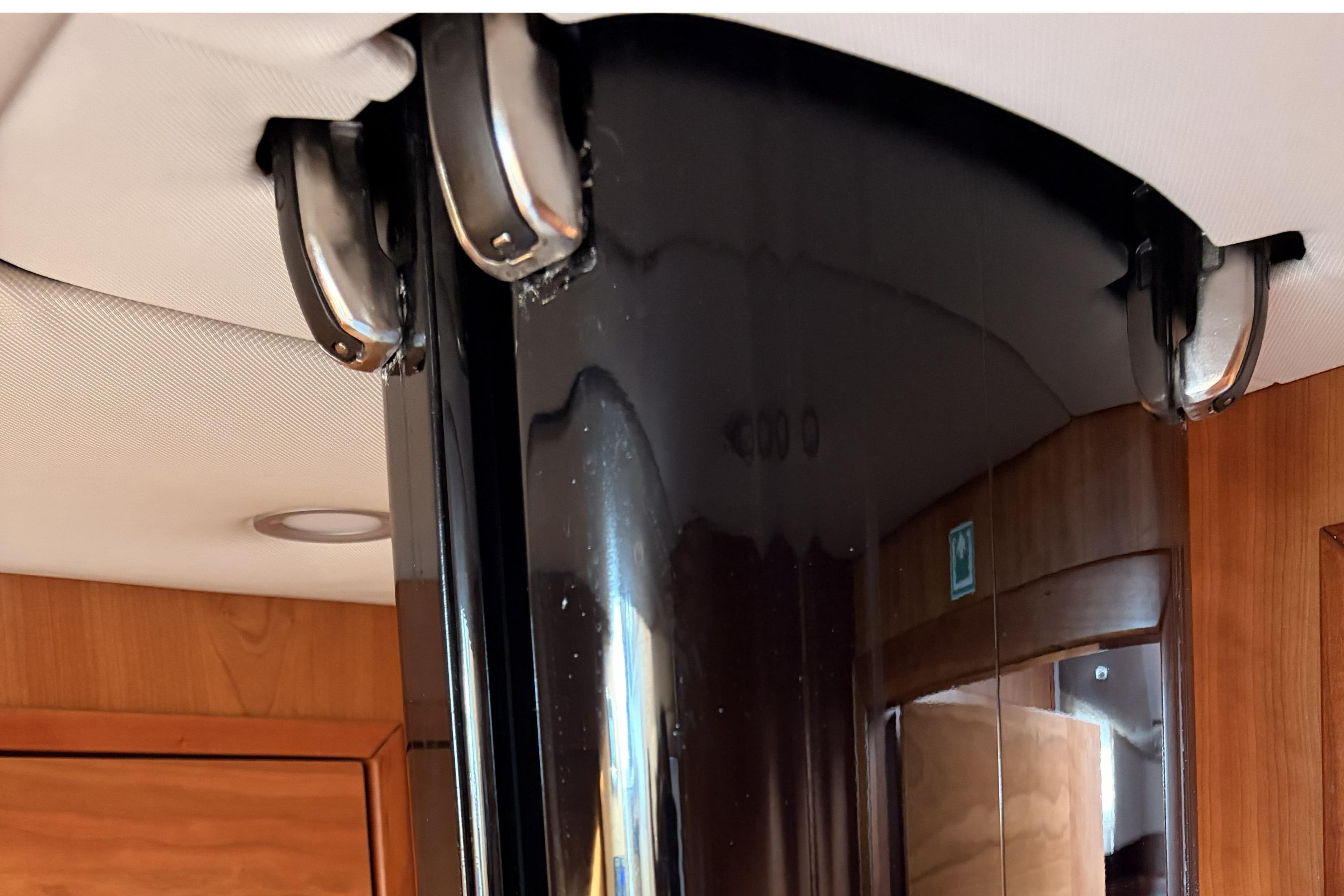 Interior view of a 2015 Moody DS54 yacht with sleek black column and wooden paneling.