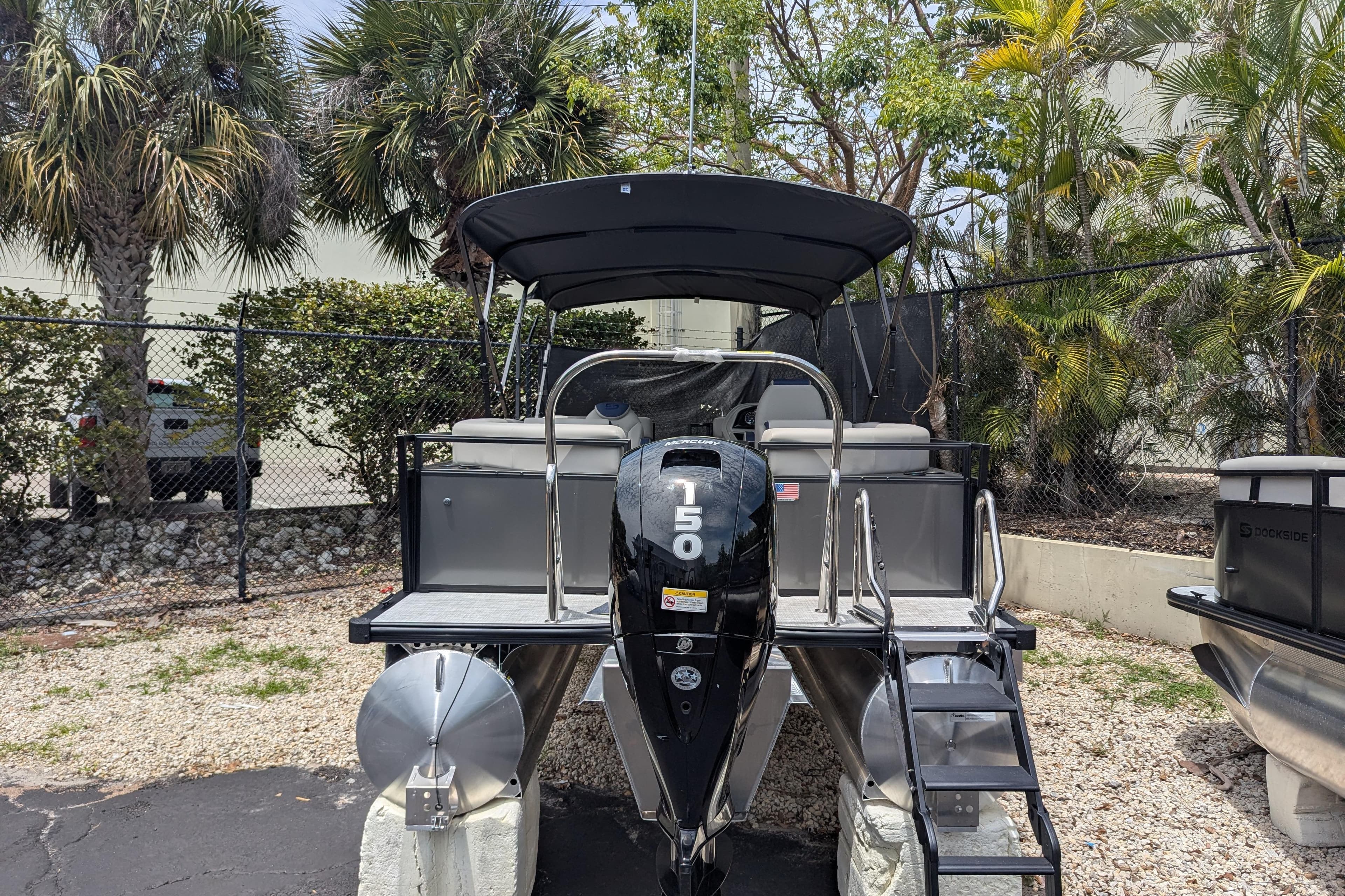 Dockside 22DQ2.75 pontoon boat, 2026 model, with 150 horsepower engine, parked outdoors.