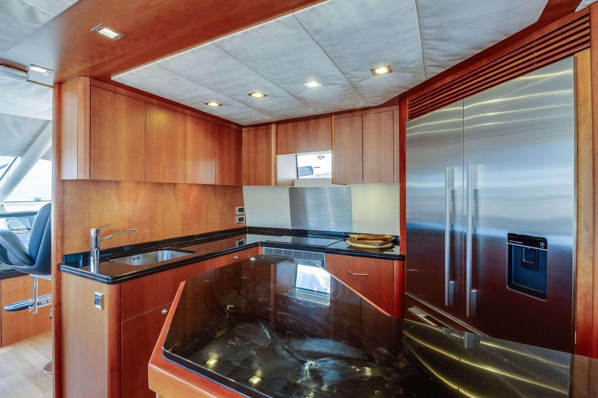 Luxurious kitchen interior of 2009 Sunseeker Manhattan 70 yacht with modern appliances and wood cabinetry.