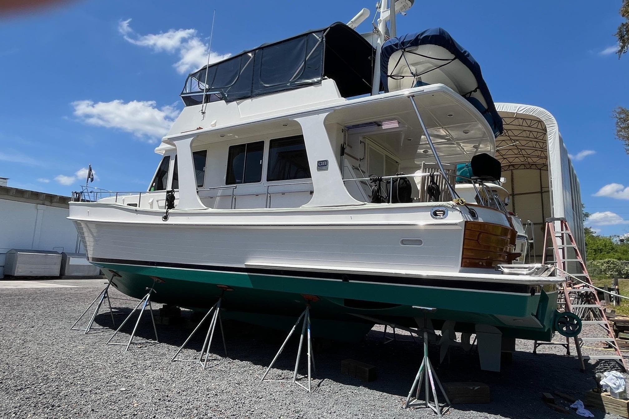 2006 Grand Banks 47 Heritage EU yacht on stands, outdoor storage, clear sky background.