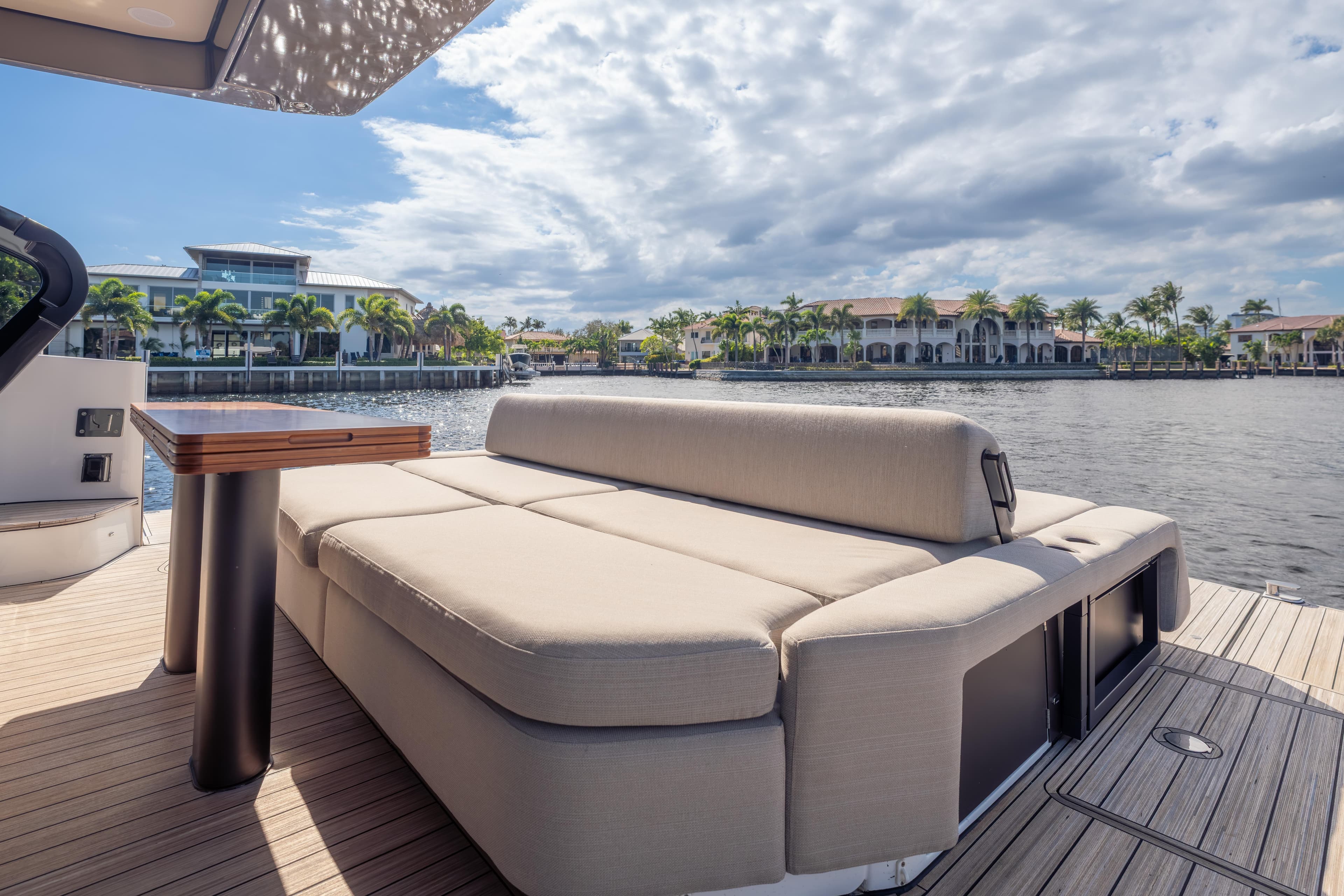 Luxurious Azimut Seadeck 6 yacht deck with plush seating, overlooking serene waterfront views.