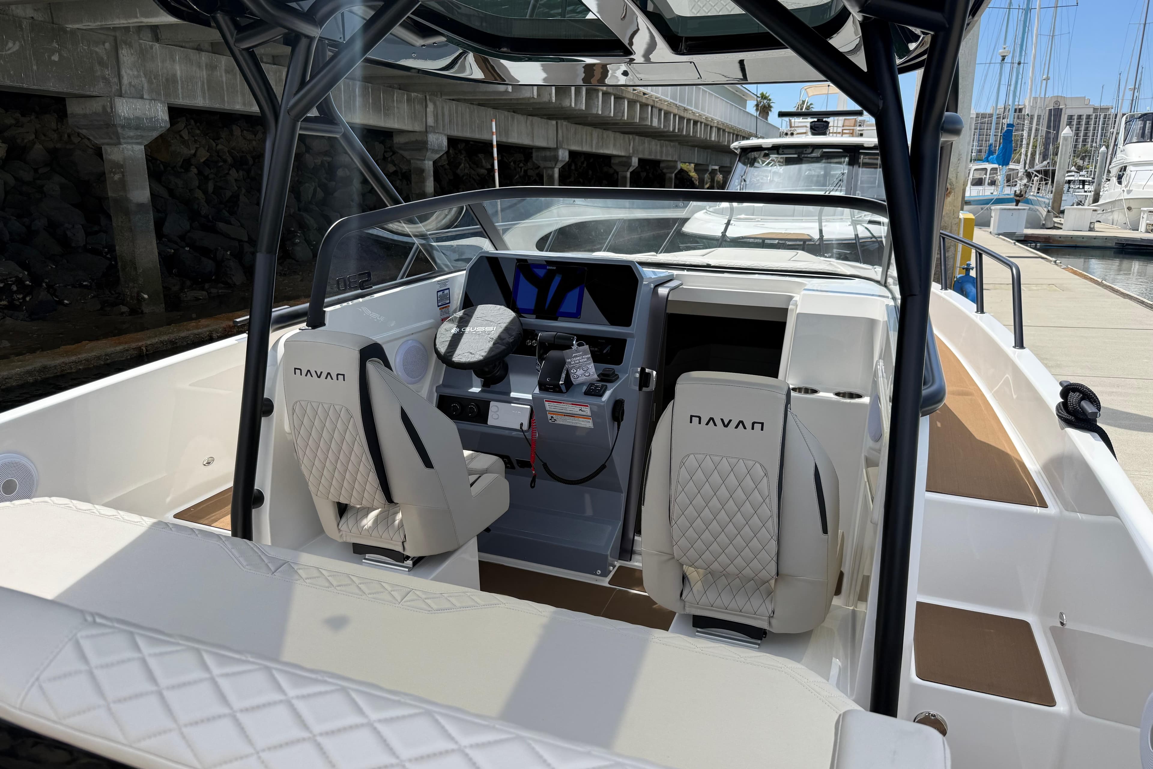 2026 Navan S30 boat interior with modern dashboard and luxurious seating at a marina.