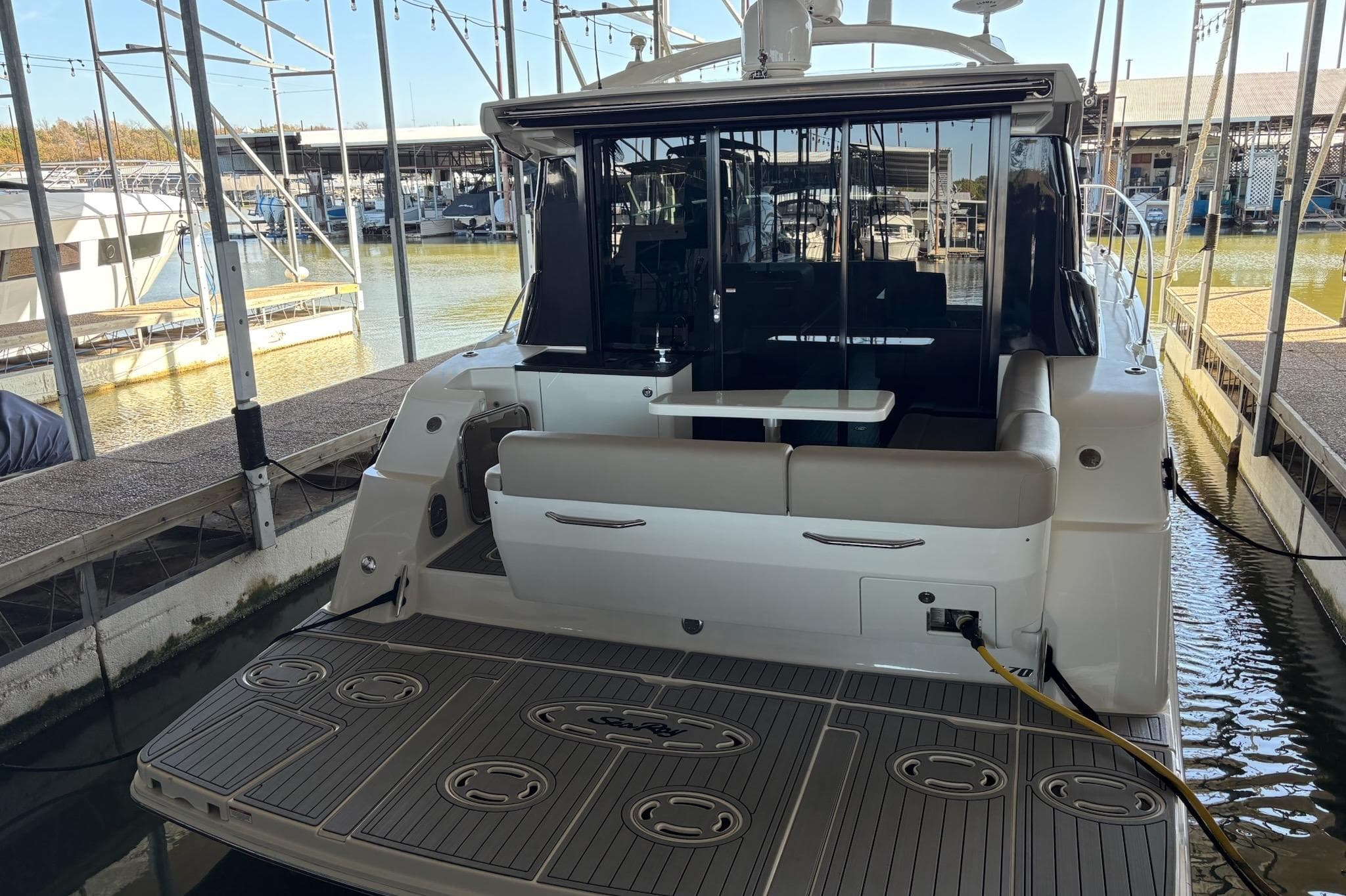 2015 Sea Ray 470 Sundancer yacht docked, showcasing spacious rear deck and seating area.