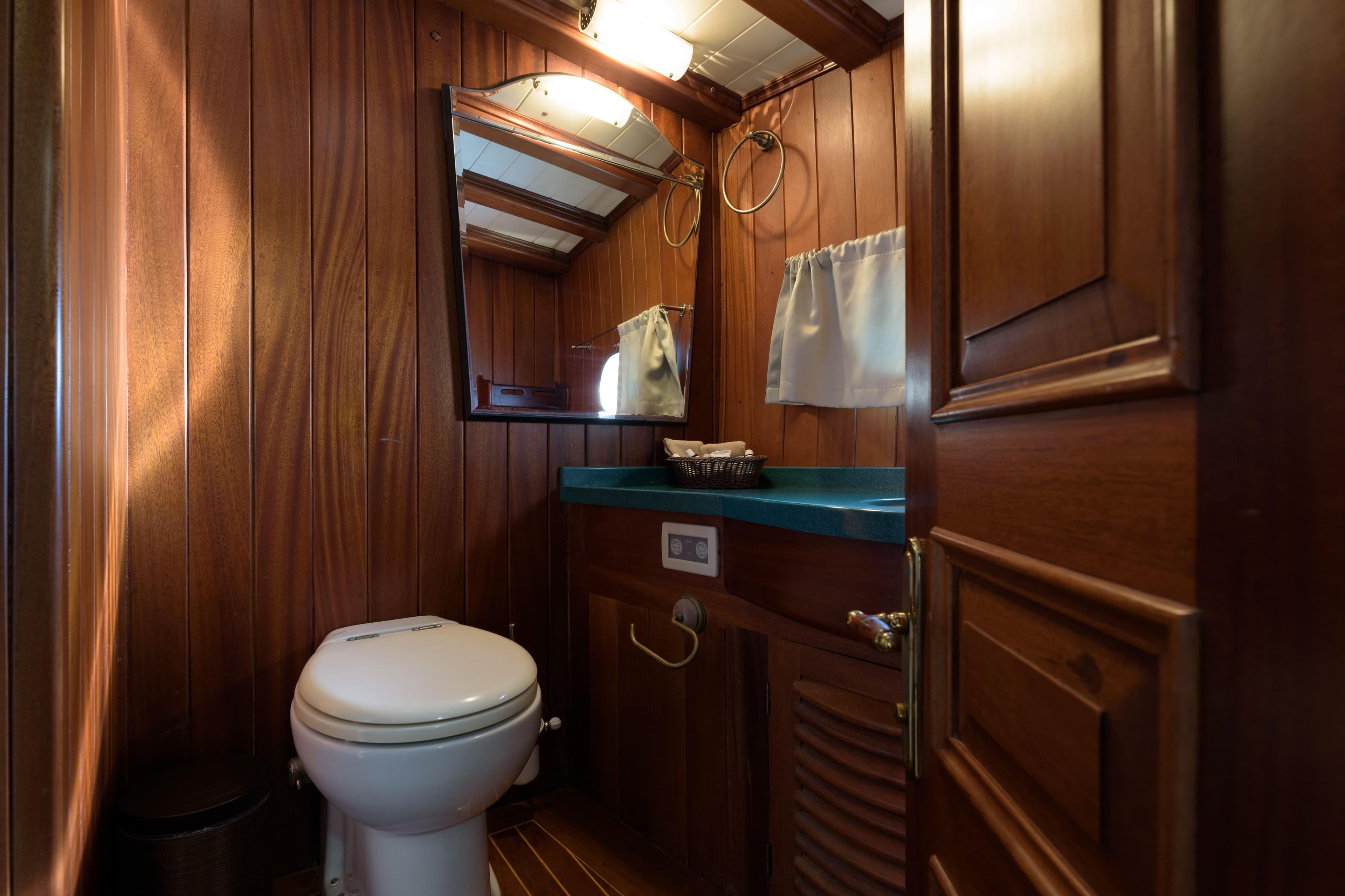 Wood-paneled bathroom on 2004 Su Marine Gulet yacht with toilet and mirror.