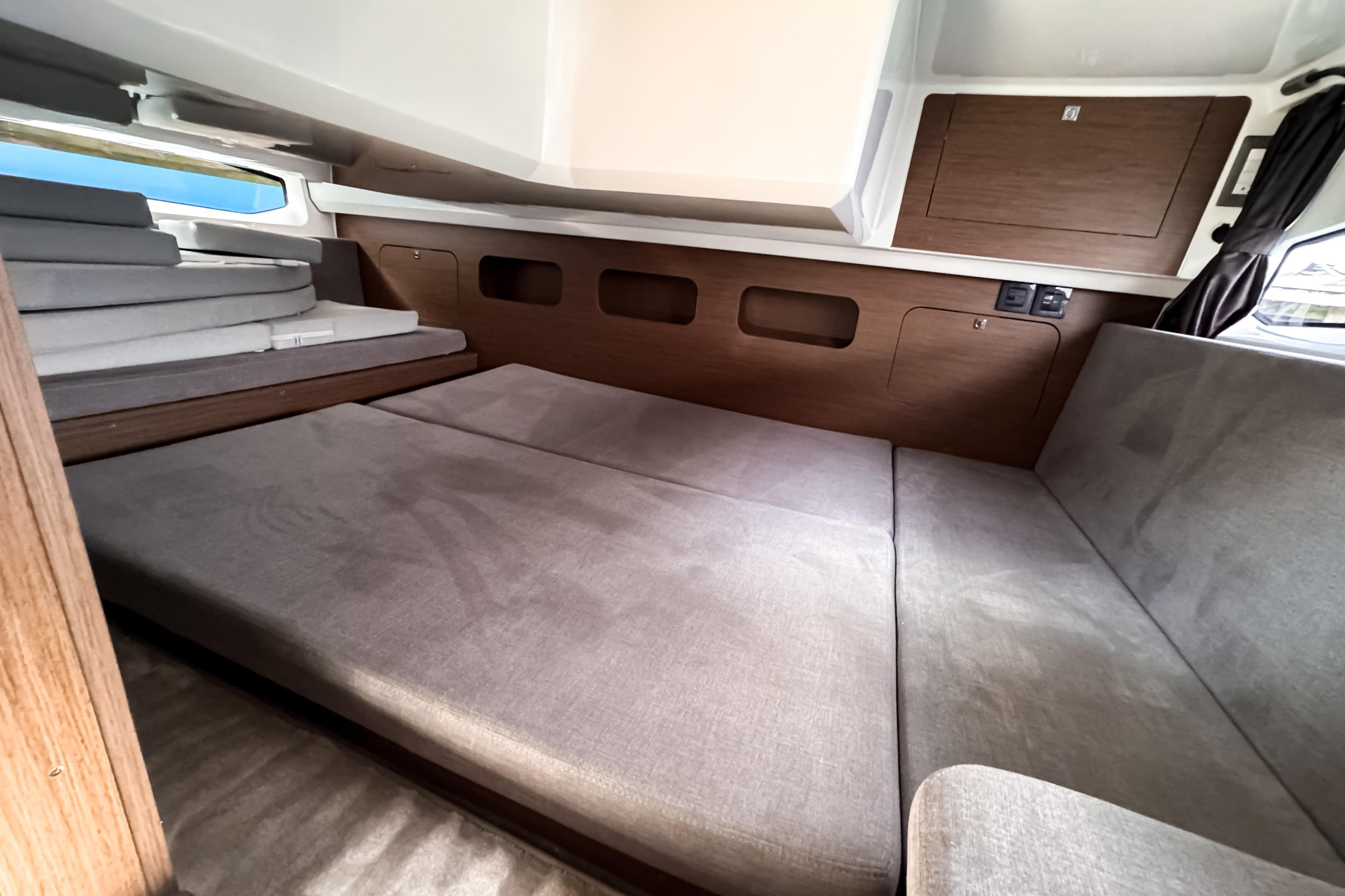 Interior cabin of 2023 Beneteau Antares 11 with cozy seating and wooden accents.