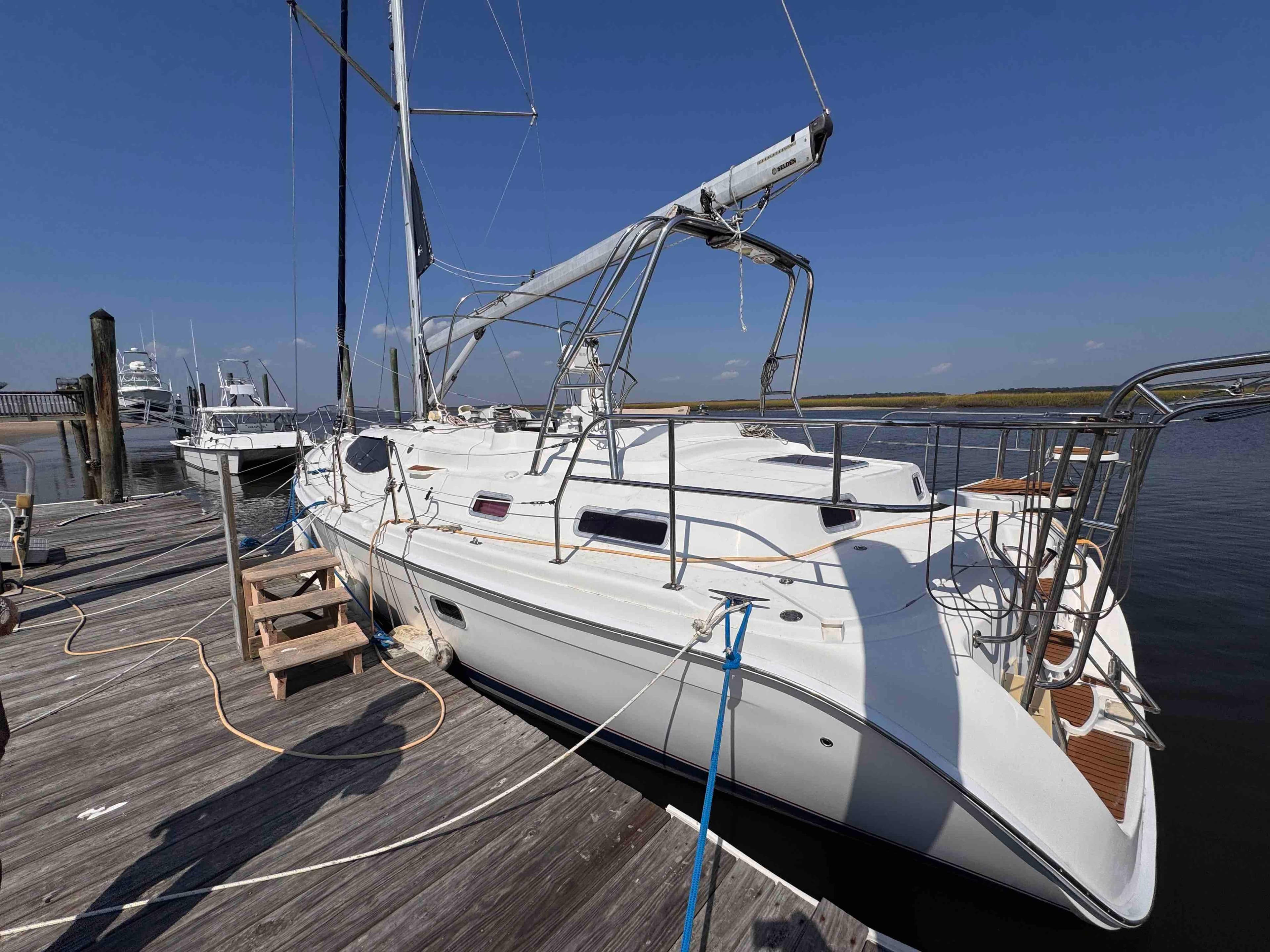 2008 Hunter 45 Center Cockpit sailboat docked at a marina under clear blue skies.