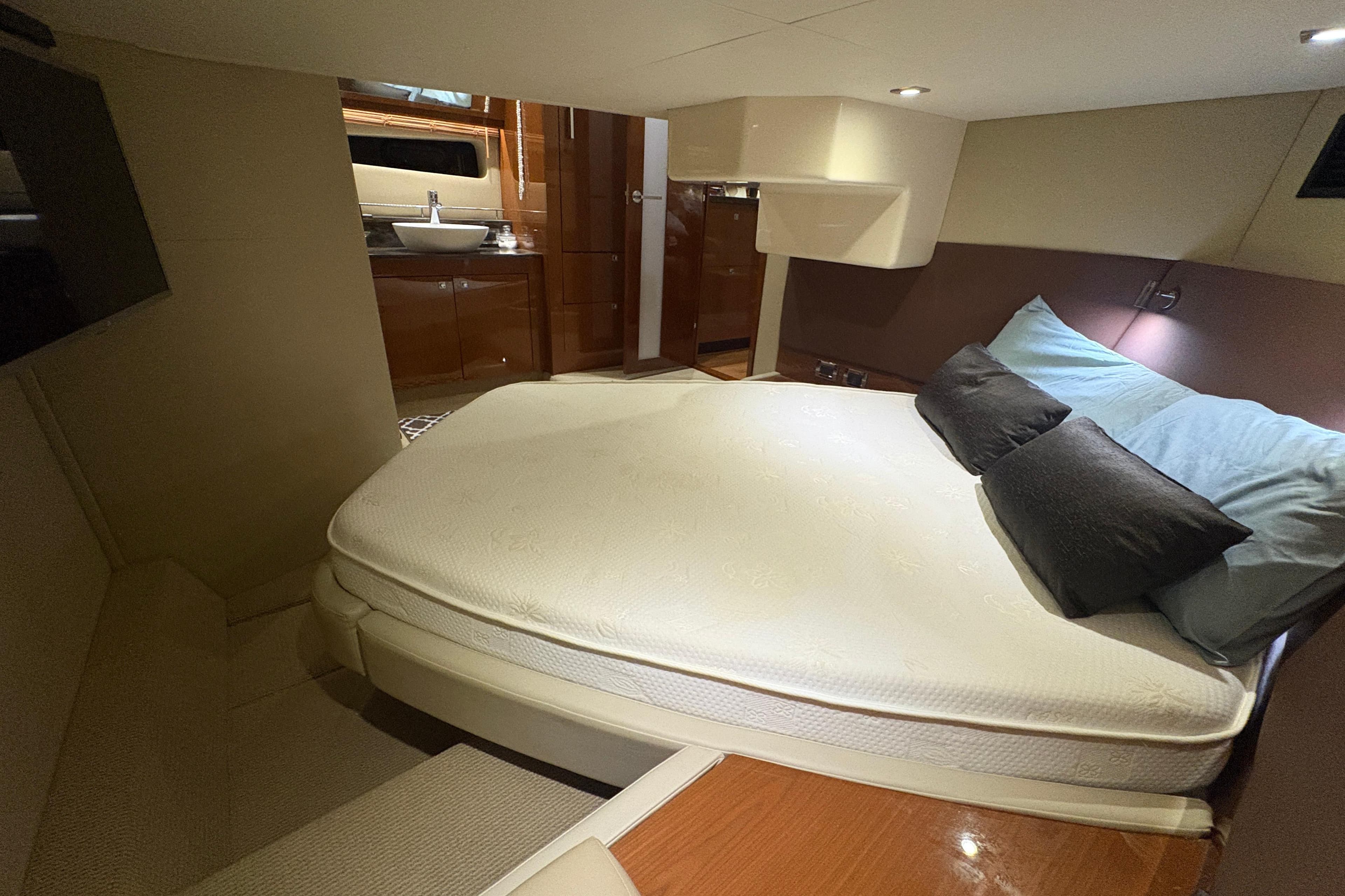 Luxurious bedroom interior of 2015 Sea Ray 470 Sundancer yacht with cozy bed and modern amenities.