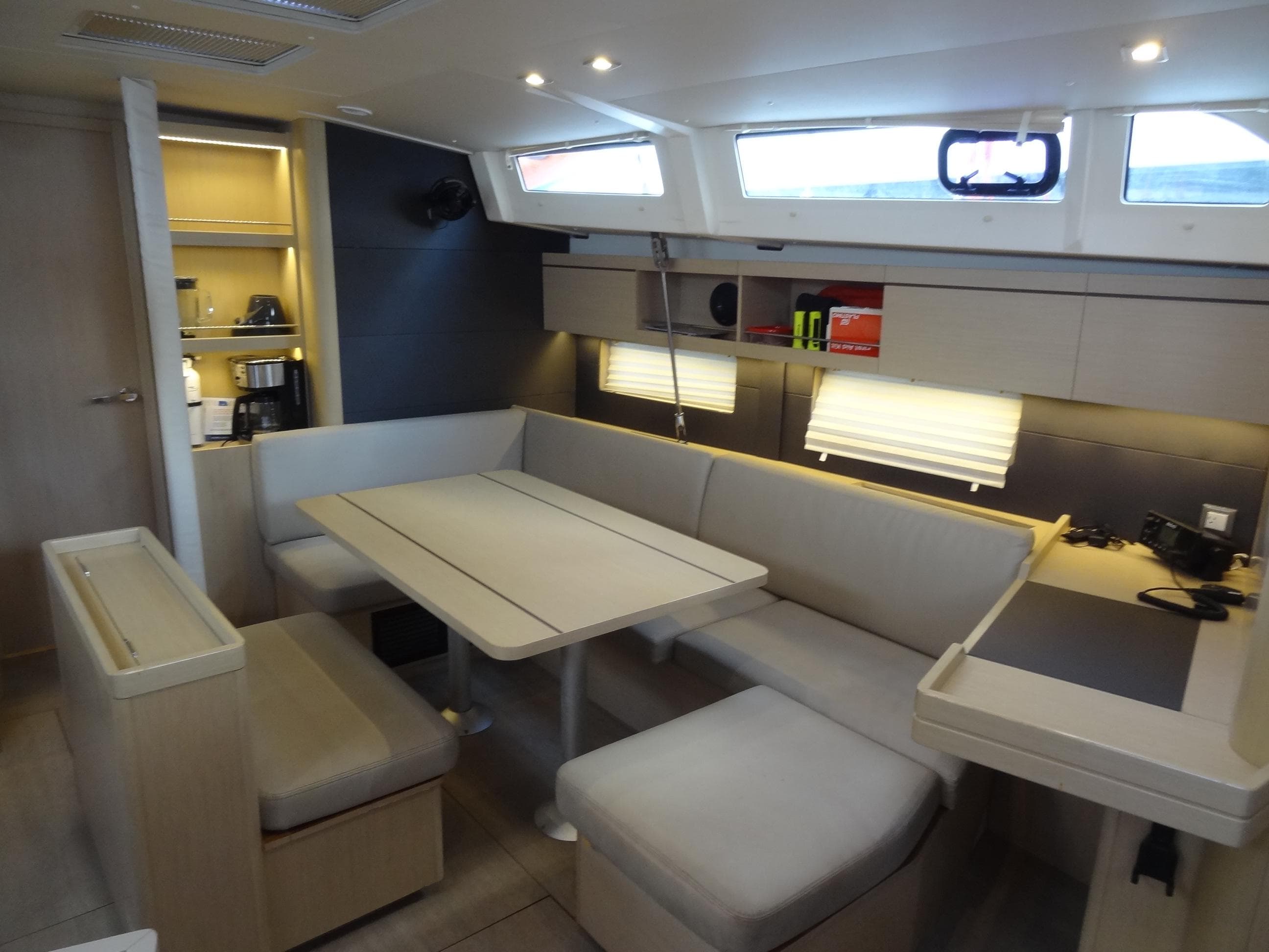 Modern interior of 2020 Beneteau Oceanis 46.1 sailboat with dining area and kitchenette.
