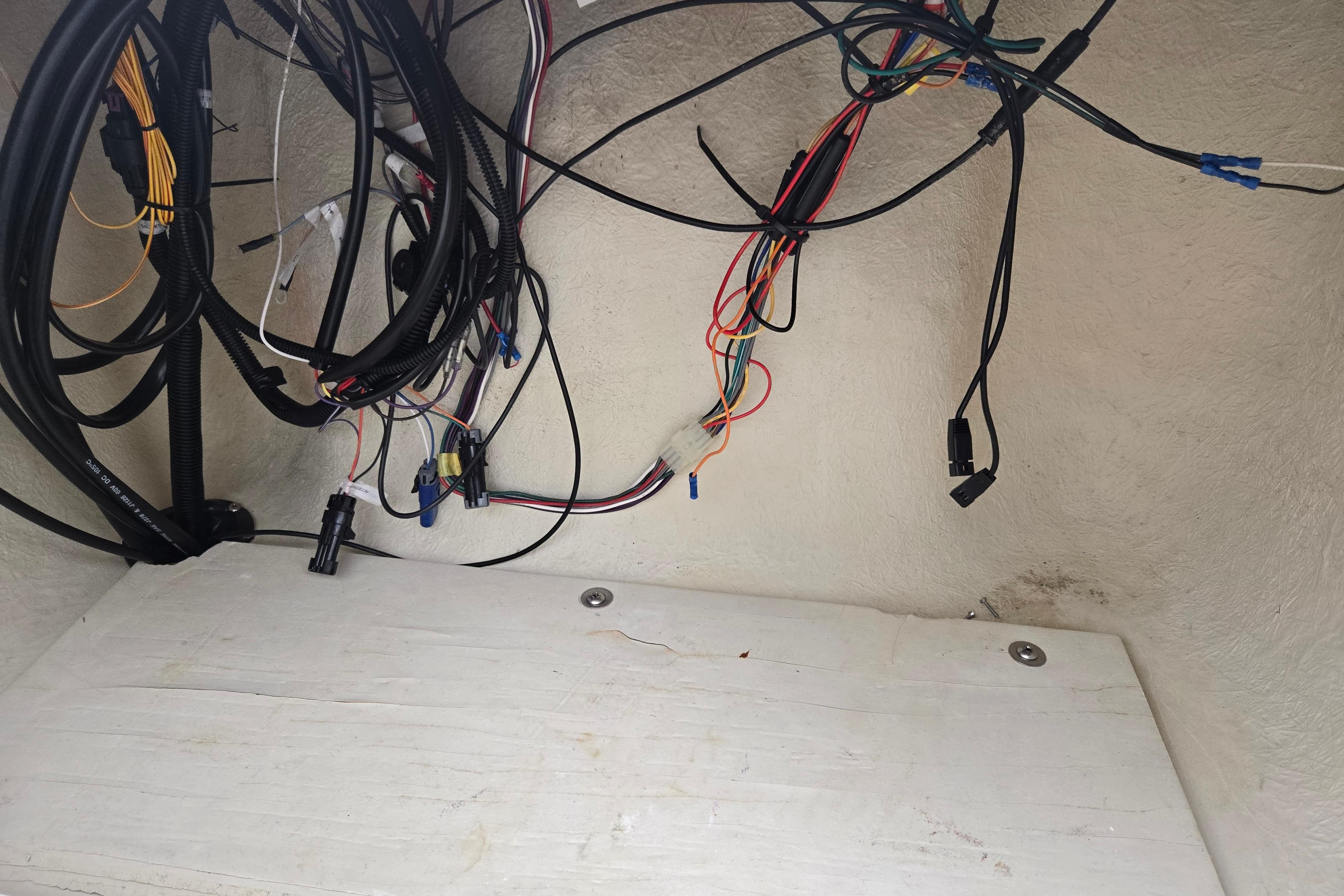 Tangled wiring inside a 2004 Odyssey Pontoons 2302 Millennium boat compartment.