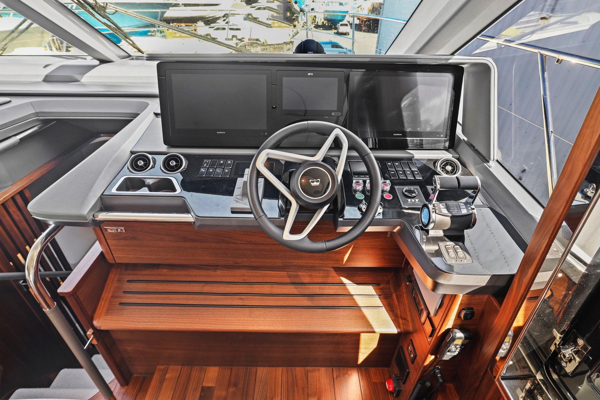 Helm of 2026 Princess F65 yacht with modern controls and wooden accents.