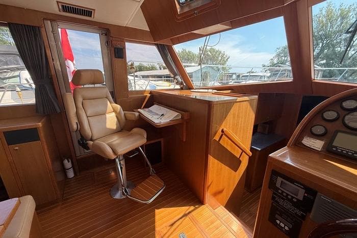 2007 Island Pilot 395 yacht interior with helm, leather chair, and navigation equipment.