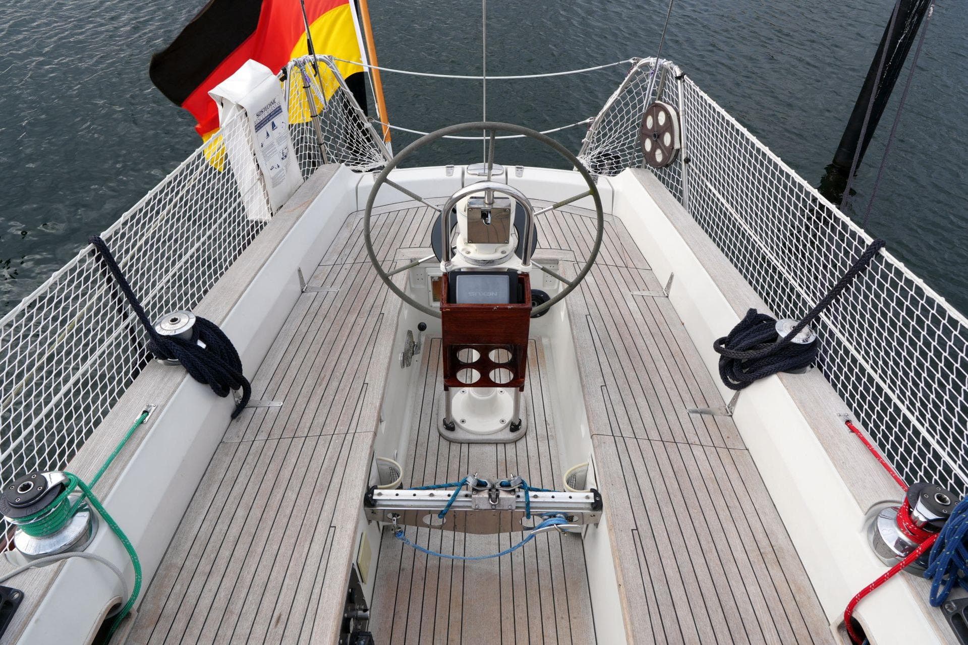 Cockpit of 1981 Bianca 414 sailboat with steering wheel, ropes, and German flag.