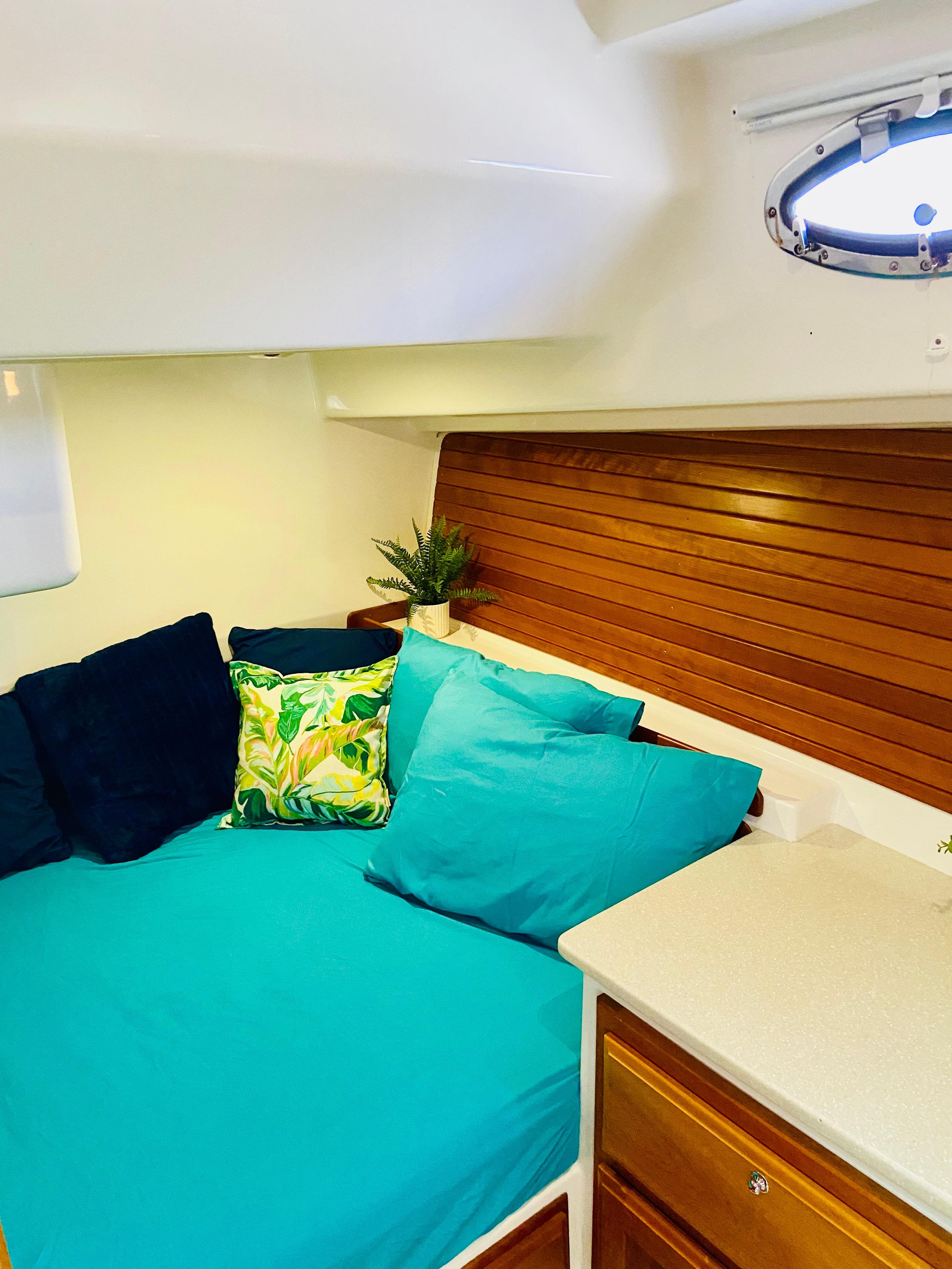 Cozy cabin interior of 2014 Back Cove 41 with vibrant cushions and wooden accents.