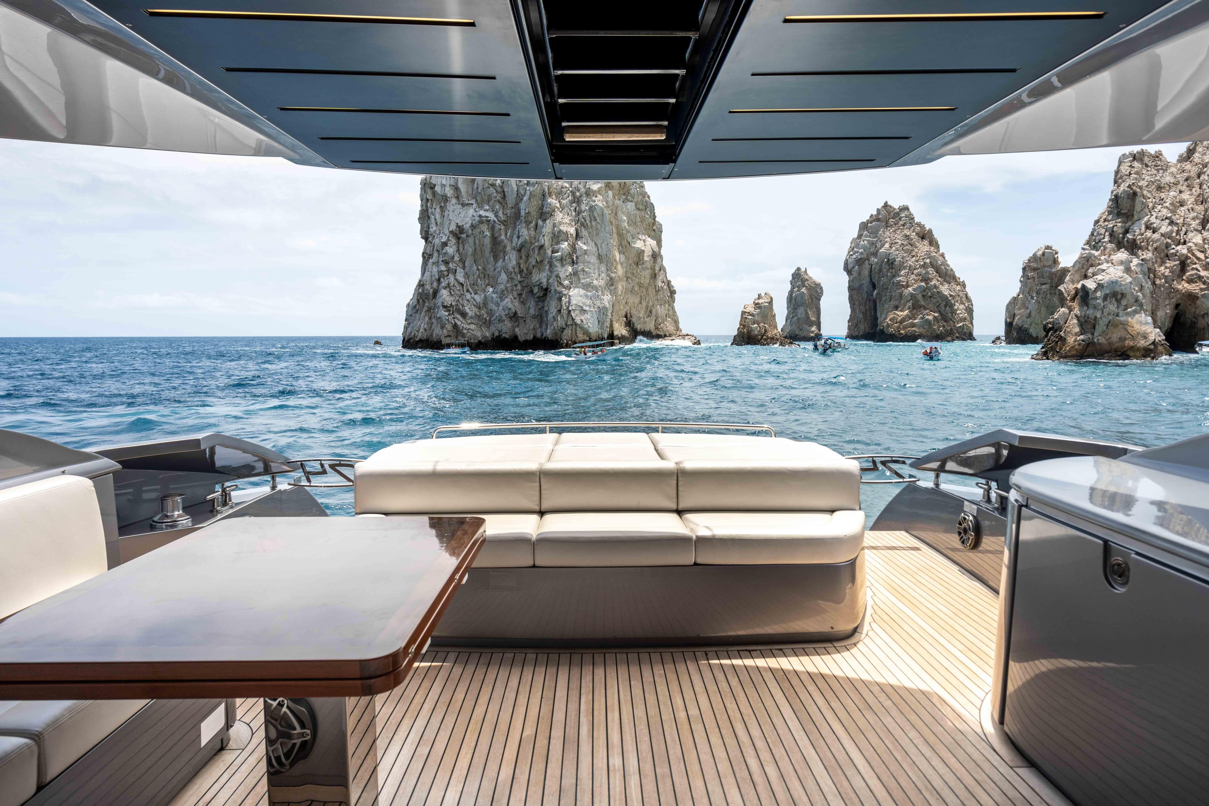 Luxurious 2017 Pershing 74 yacht with ocean view and rock formations.