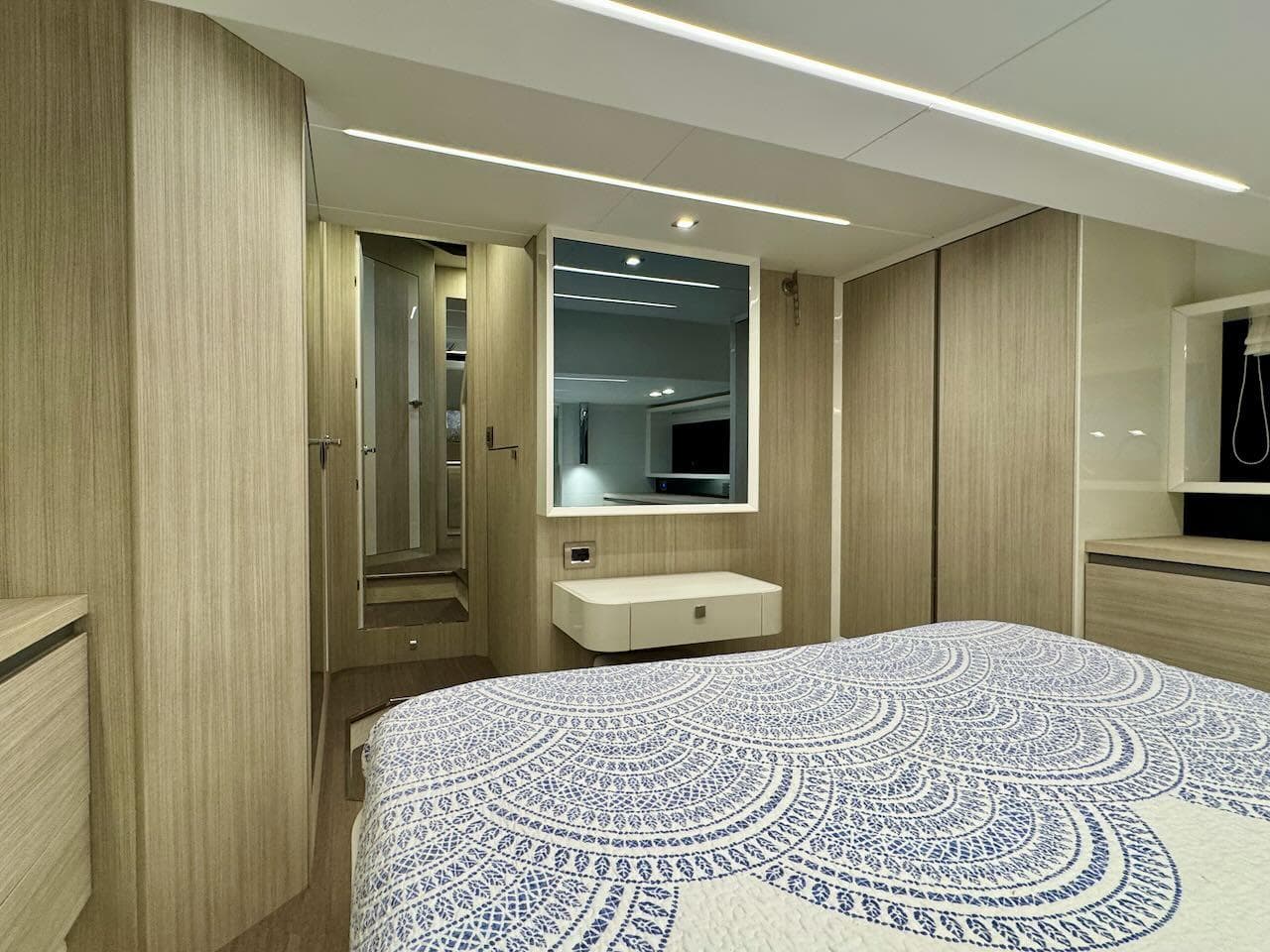 Luxurious 2017 Cranchi E 52 F yacht bedroom with modern decor and elegant bedding.
