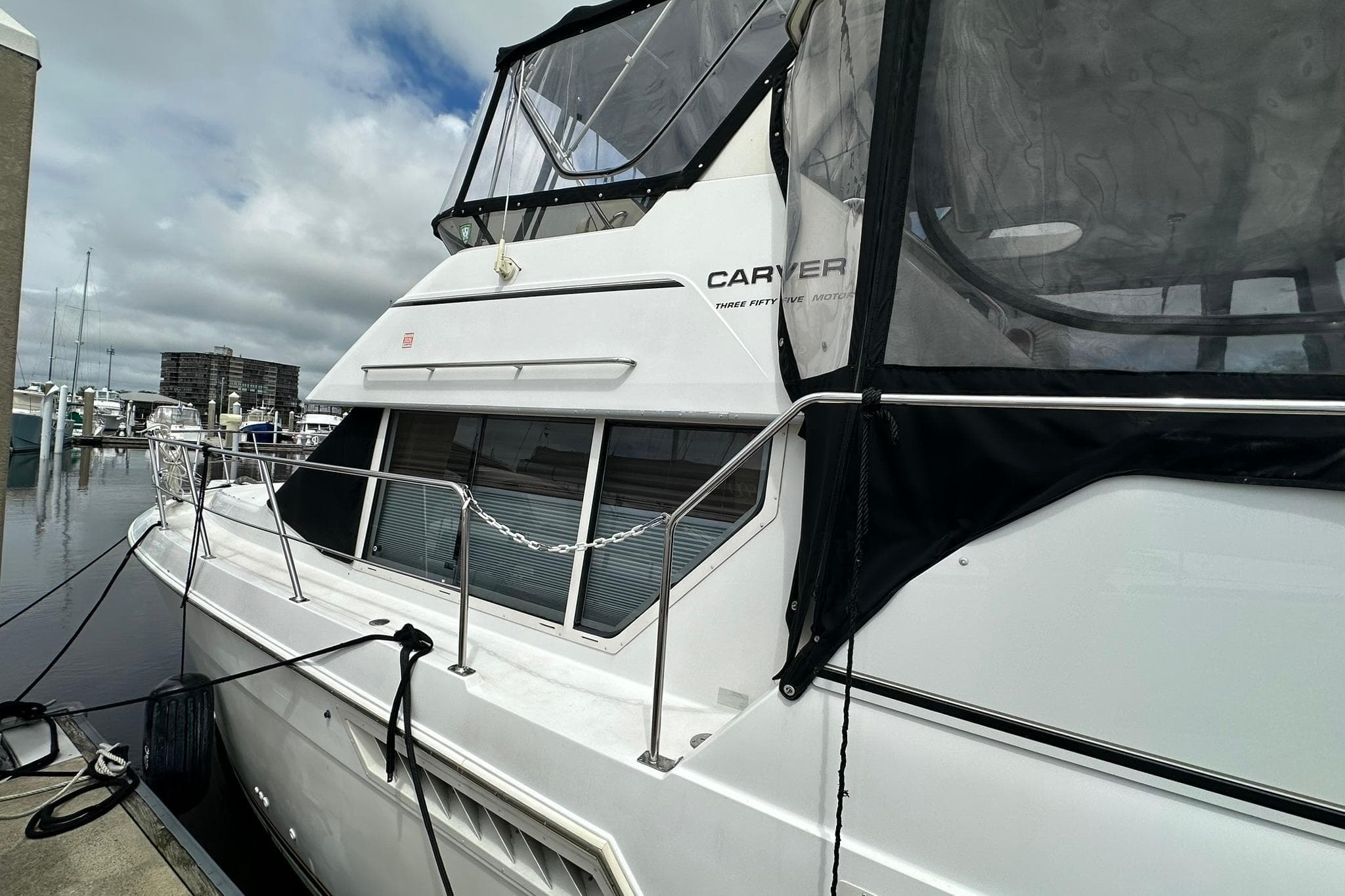 1997 Carver 355 Aft Cabin Motor Yacht docked at marina under cloudy skies.