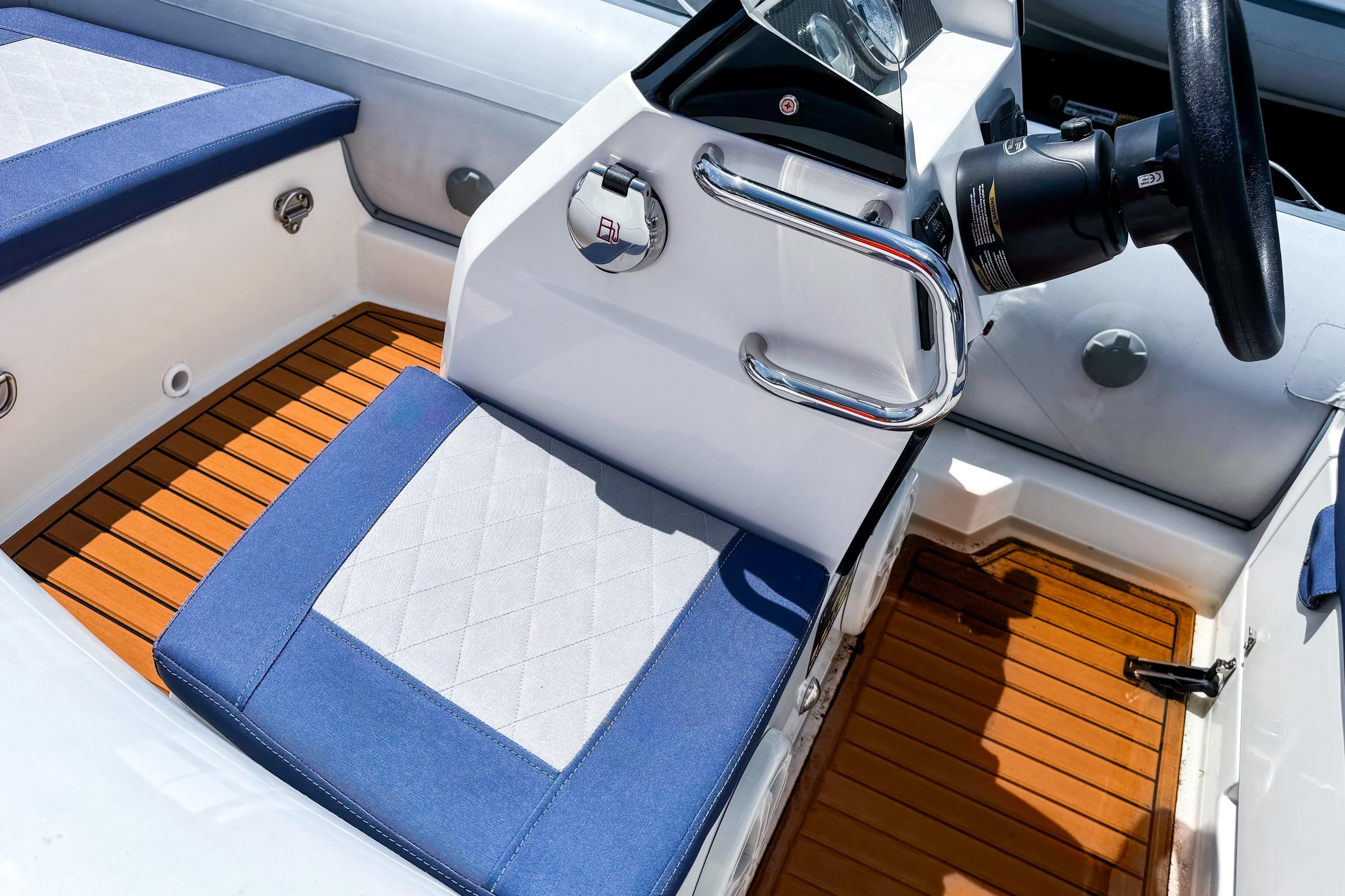 Interior of 2022 Northstar Axis 3.1 boat with blue and white seating, wooden flooring.