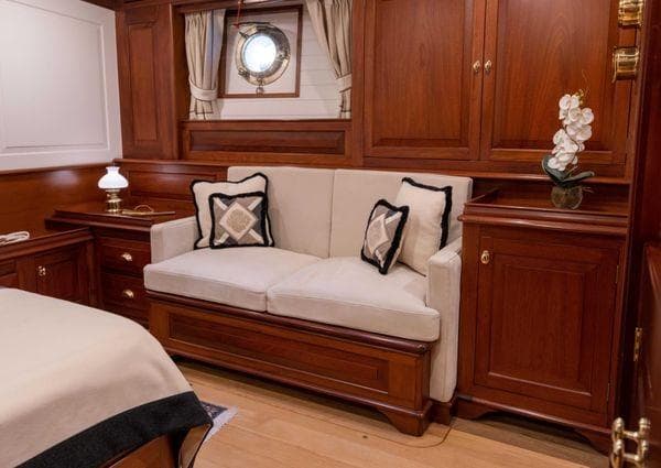 Luxurious wooden interior of a 2014 Custom 52m yacht with a cozy sofa and elegant decor.