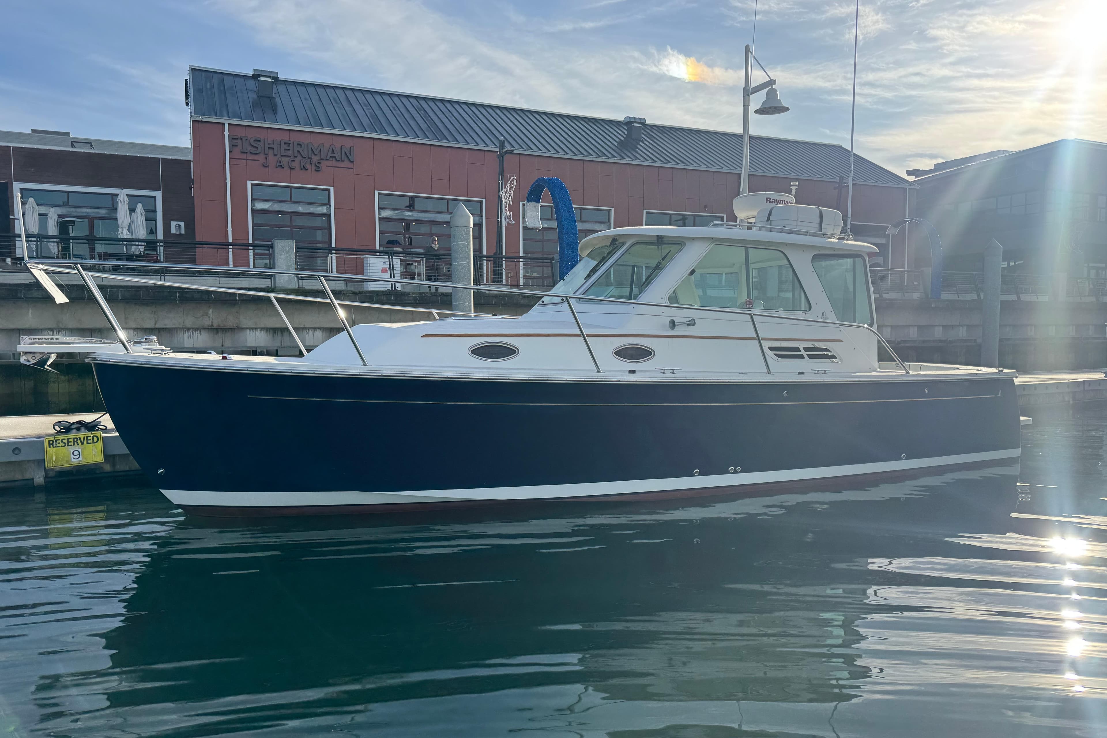 2008 Back Cove 29 Hardback boat docked near Fisherman building.