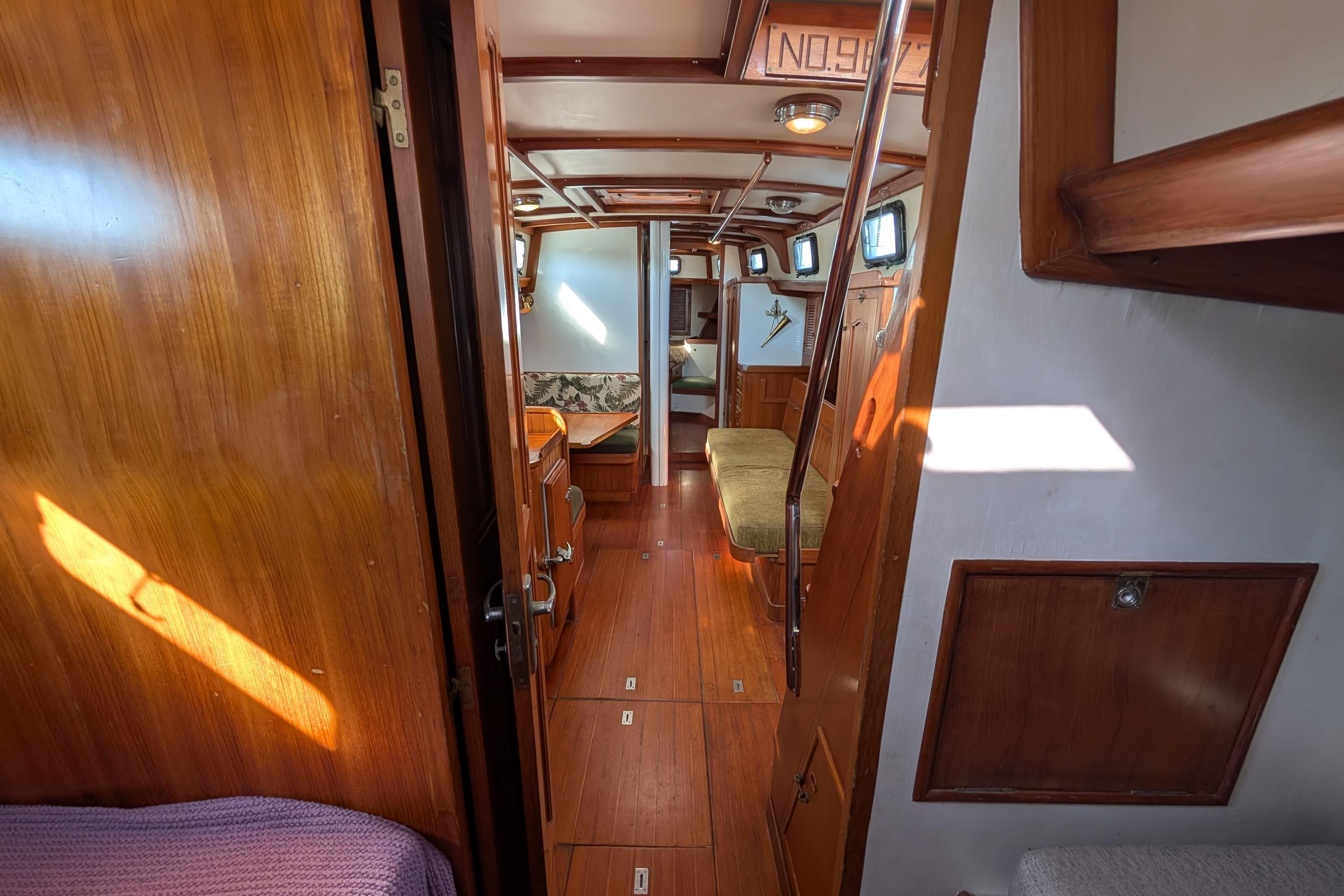 Interior of 1981 Mason 43 yacht with wooden furnishings and cozy seating area.