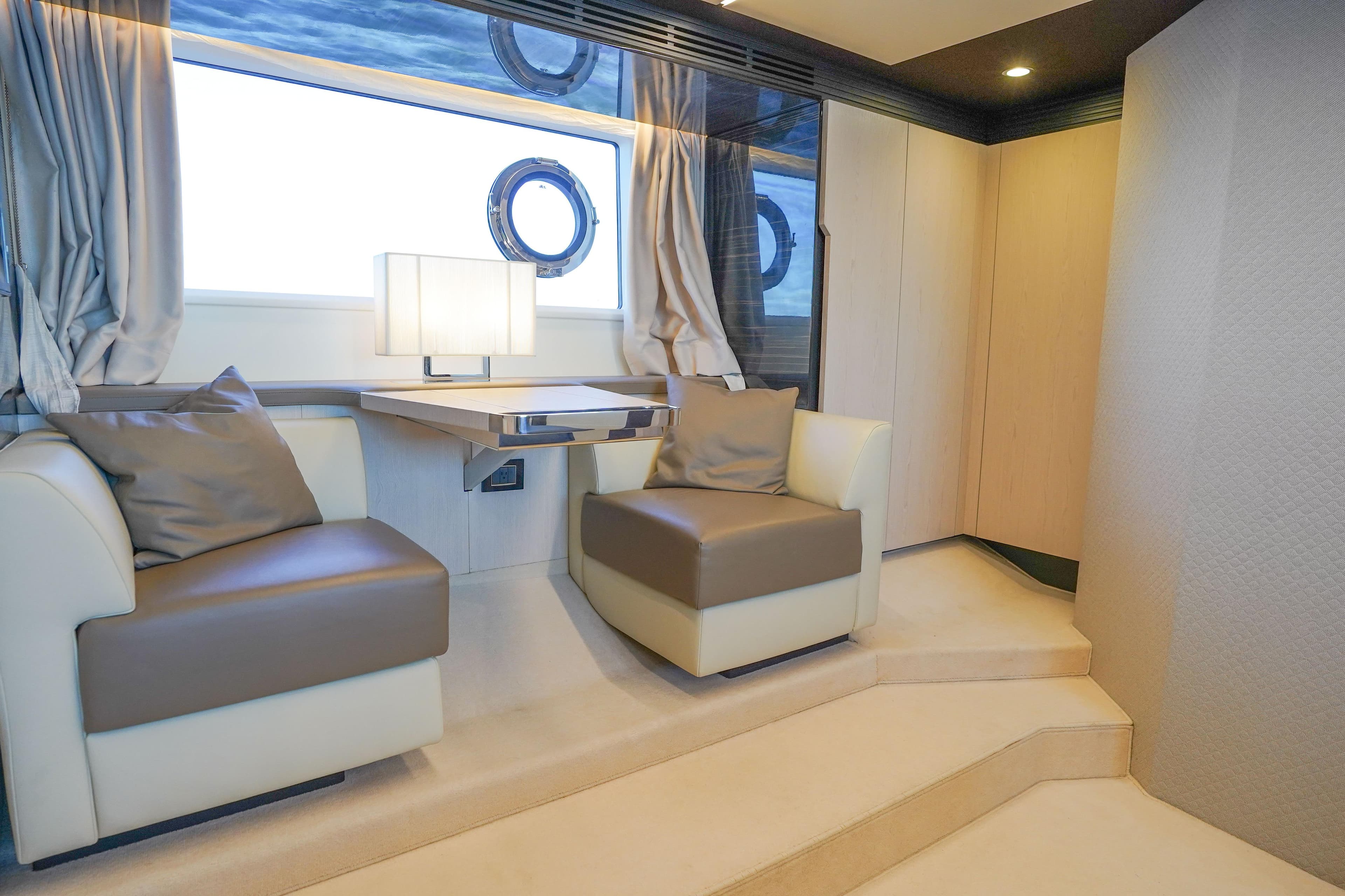 Luxurious interior of 2017 Azimut 66 Flybridge yacht with elegant seating and window view.