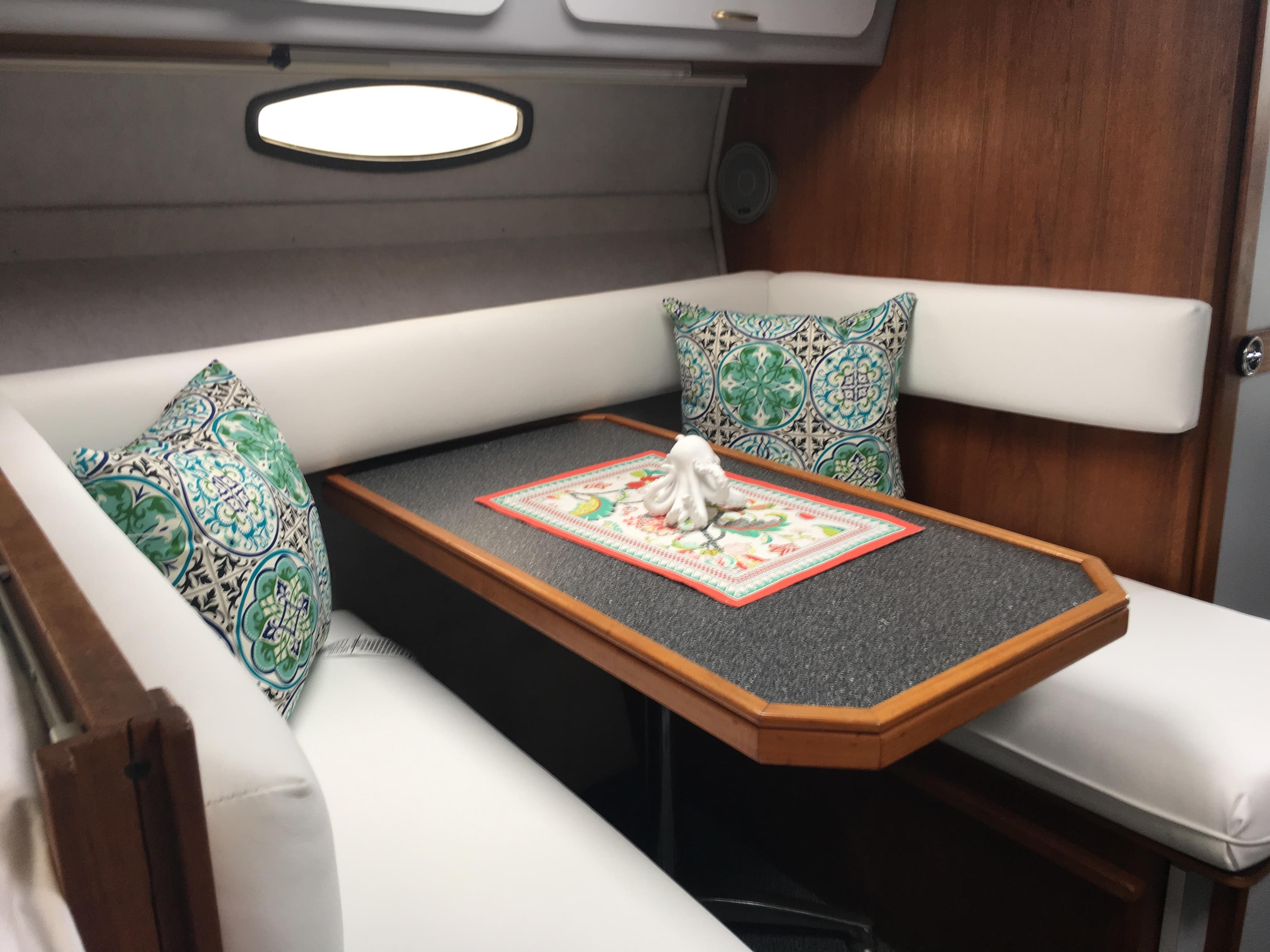 Interior of 1989 Cruisers Yachts 3060 Rogue with cozy seating and decorative pillows.