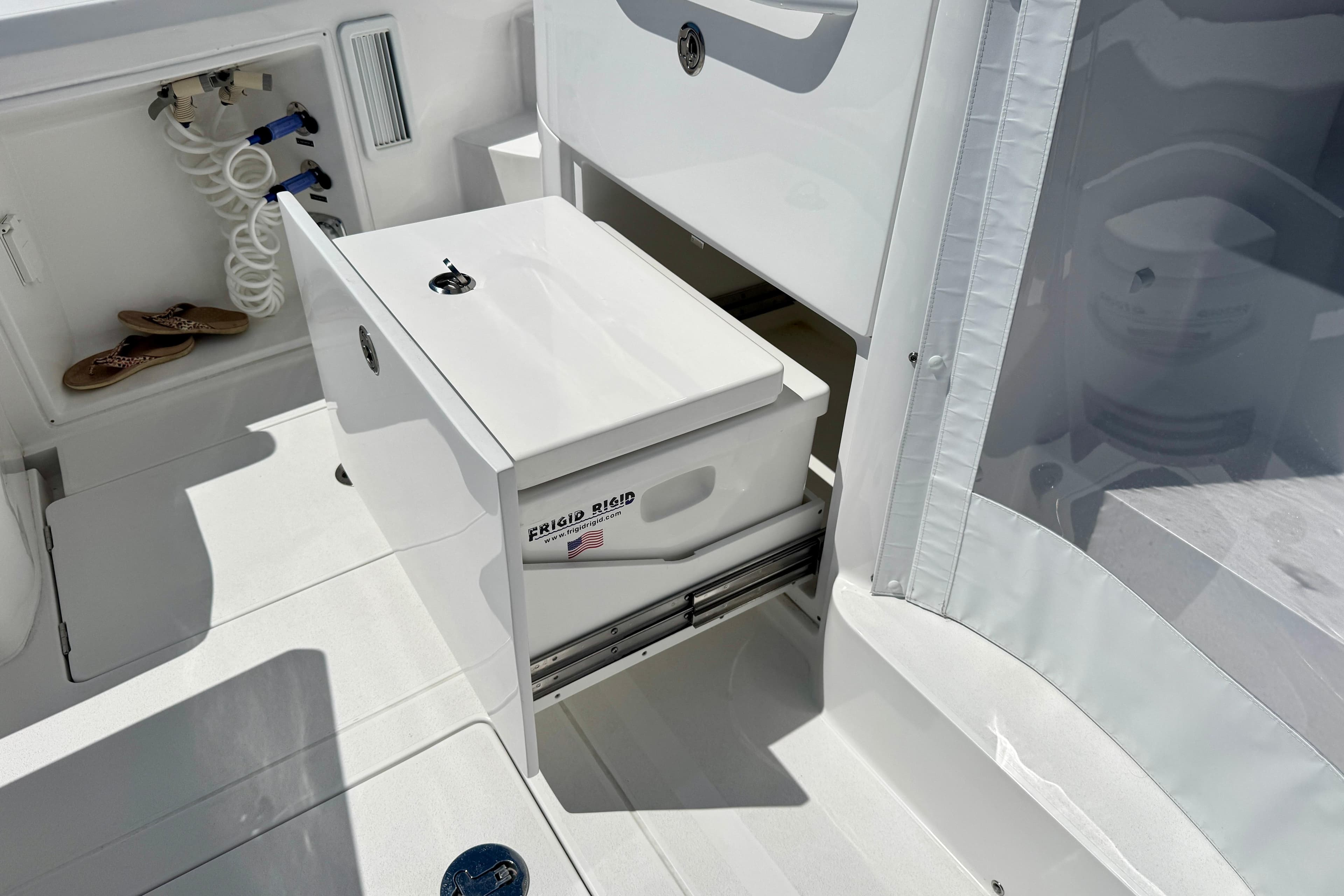 Intrepid 50 Evolution 2025 boat interior with storage compartment and hose.
